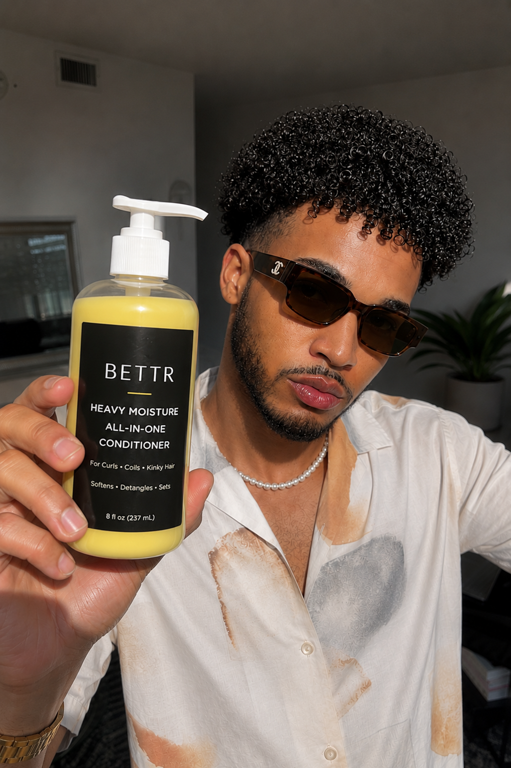 The Founder holding a bottle of BETTR Heavy Moisture All-in-One Conditioner.