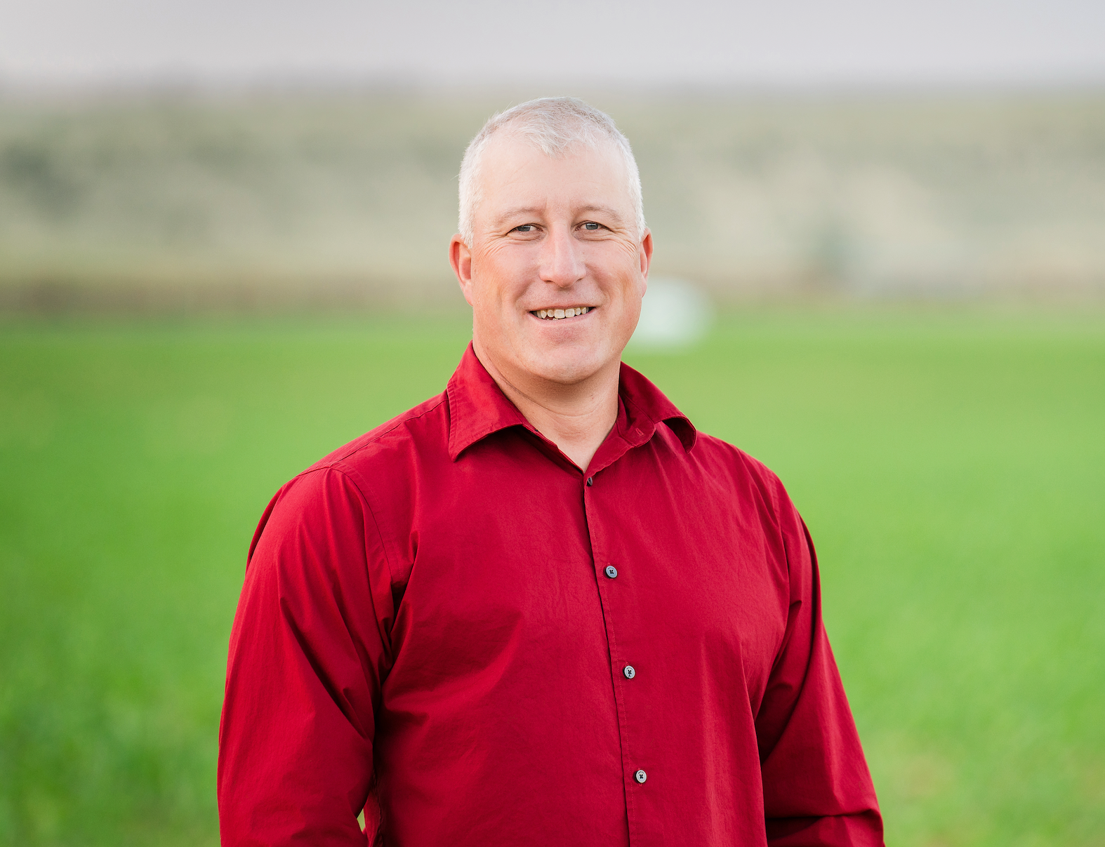 Portrait of Joe Speckner, candidate for Wyoming House District 5, smiling in a red shirt