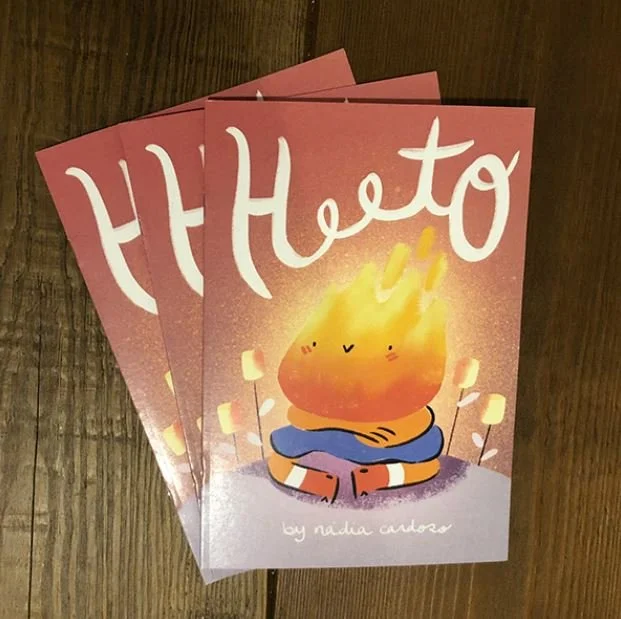 Cards with a cartoon illustration of a fire character sitting cross-legged, glowing with warmth, with the word "Hello" written at the top and the author's name Nadia Cardoso at the bottom.