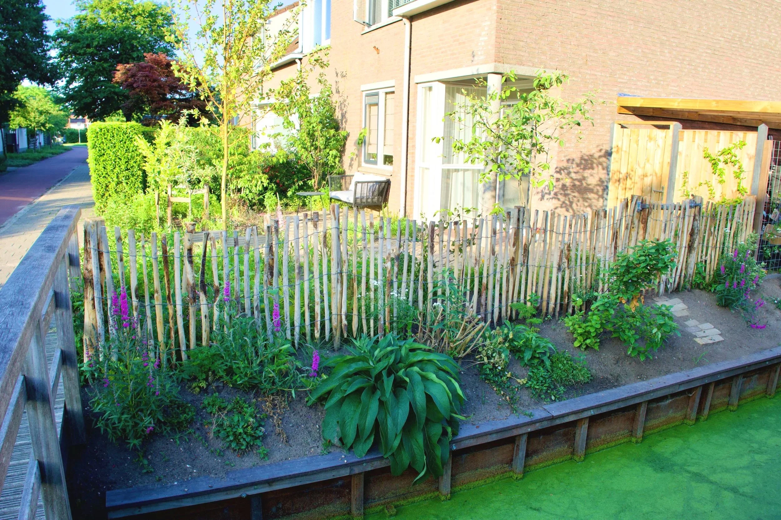 Kastanjehek geeft een rustieke uitstraling, voldoende effectief om te voorkomen dat de kinderen bij het water kunnen komen, maar blijft er wel voor zorgen dat de beplanting aan de waterzijde nog steeds te zien is en bij de tuin hoort. 
