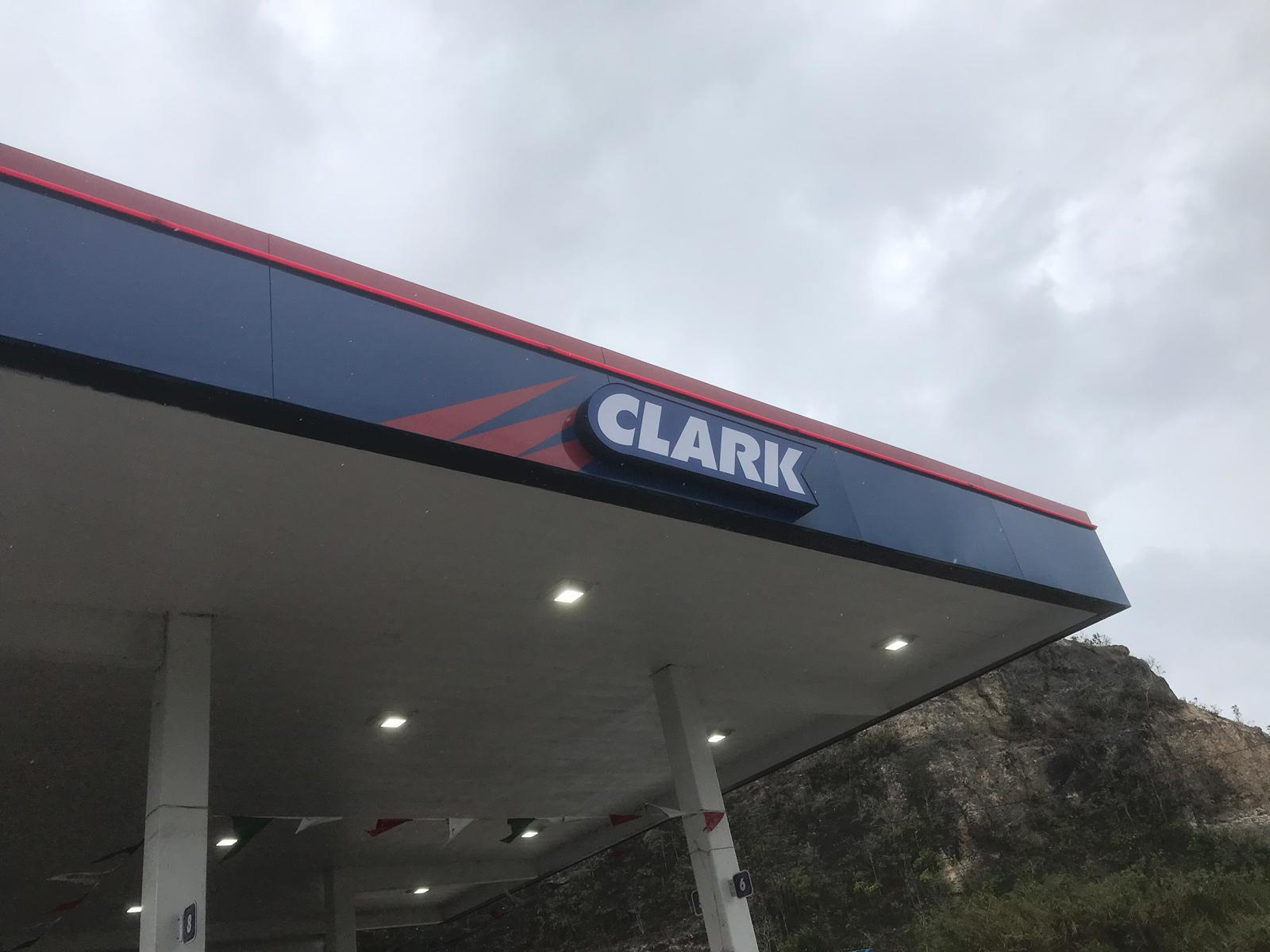 Estación de carga de combustible Clark bajo cielo nublado.