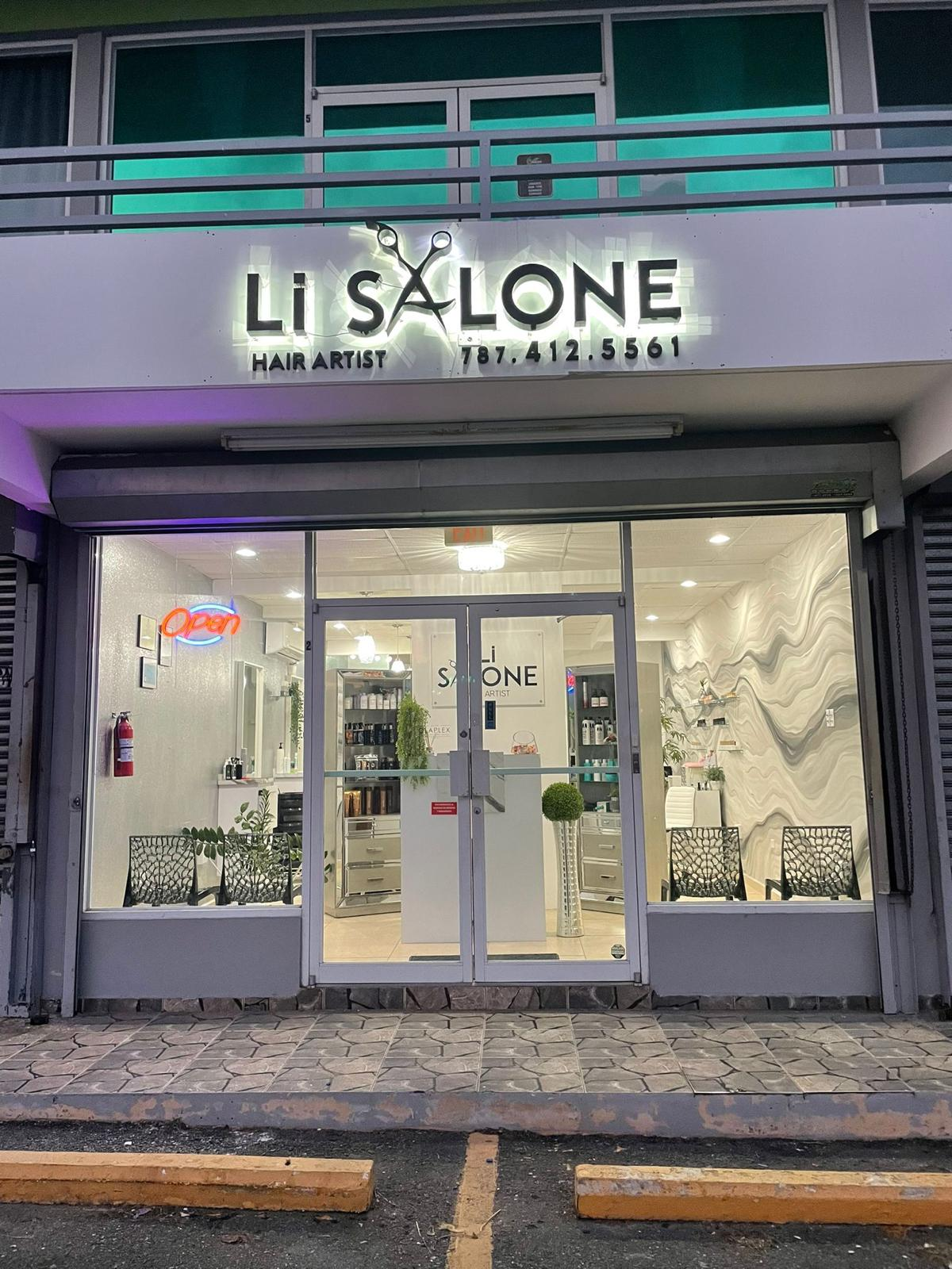Fachada de un salón de belleza llamado 'Li Salone' con letrero luminoso, puertas de cristal y decoración interior moderna, con plantas y sillas.