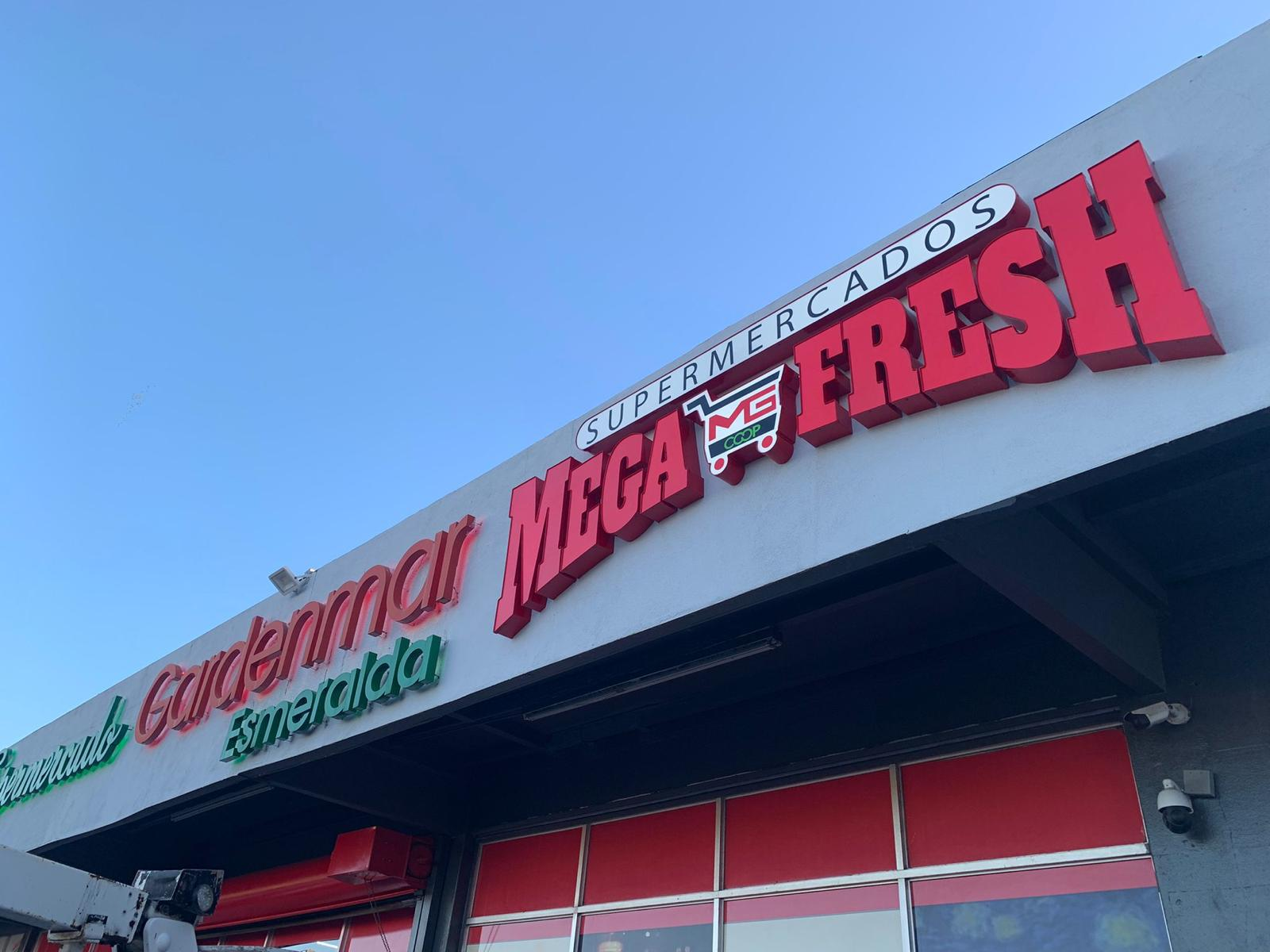 Cartel de supermercado grande y en letras rojas que dice "Mega Fresh" con un carrito de compras en medio del texto. También se lee "Supermercados" en letras pequeñas y "Esmeralda" en letras verdes.