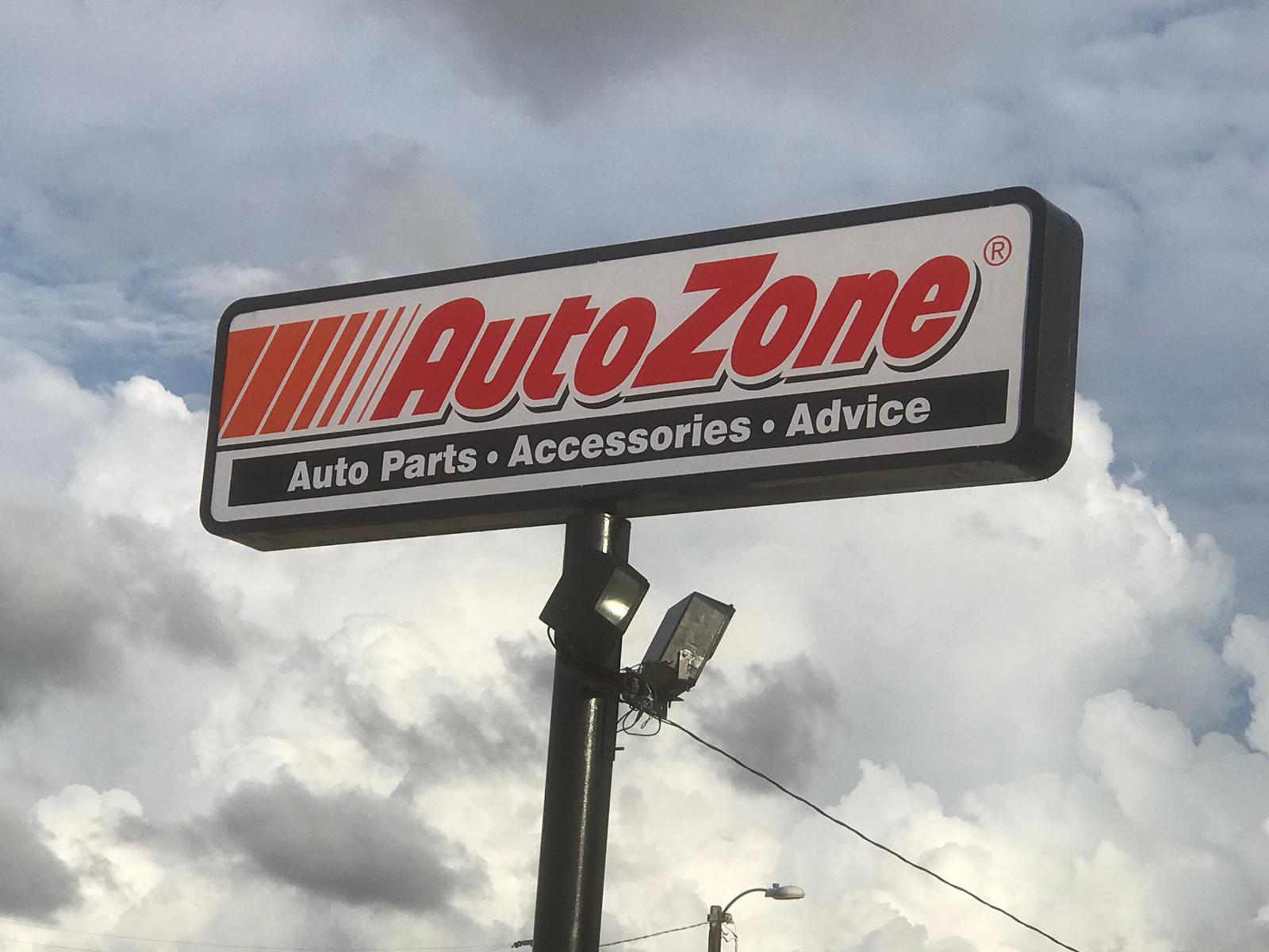 Señal de tienda que dice autocad de piezas, accesorios y consejos para autos, con cielo nublado de fondo.