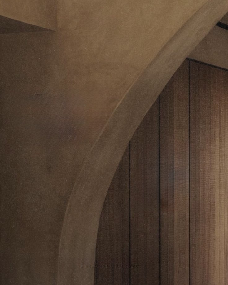 Close-up of a curved ceiling and wooden wall panels in a room interior.