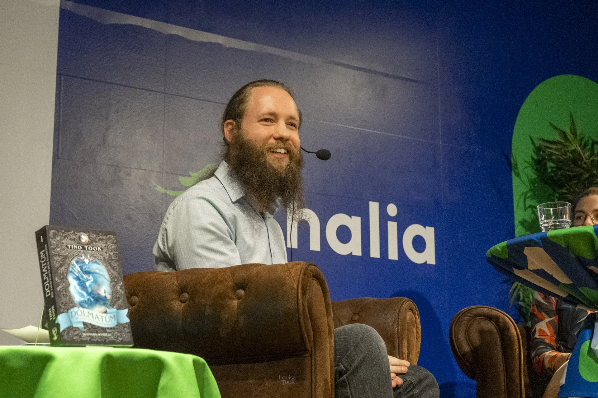 Lively event photography showing an author speaking on stage at a corporate event while engaging with his audience