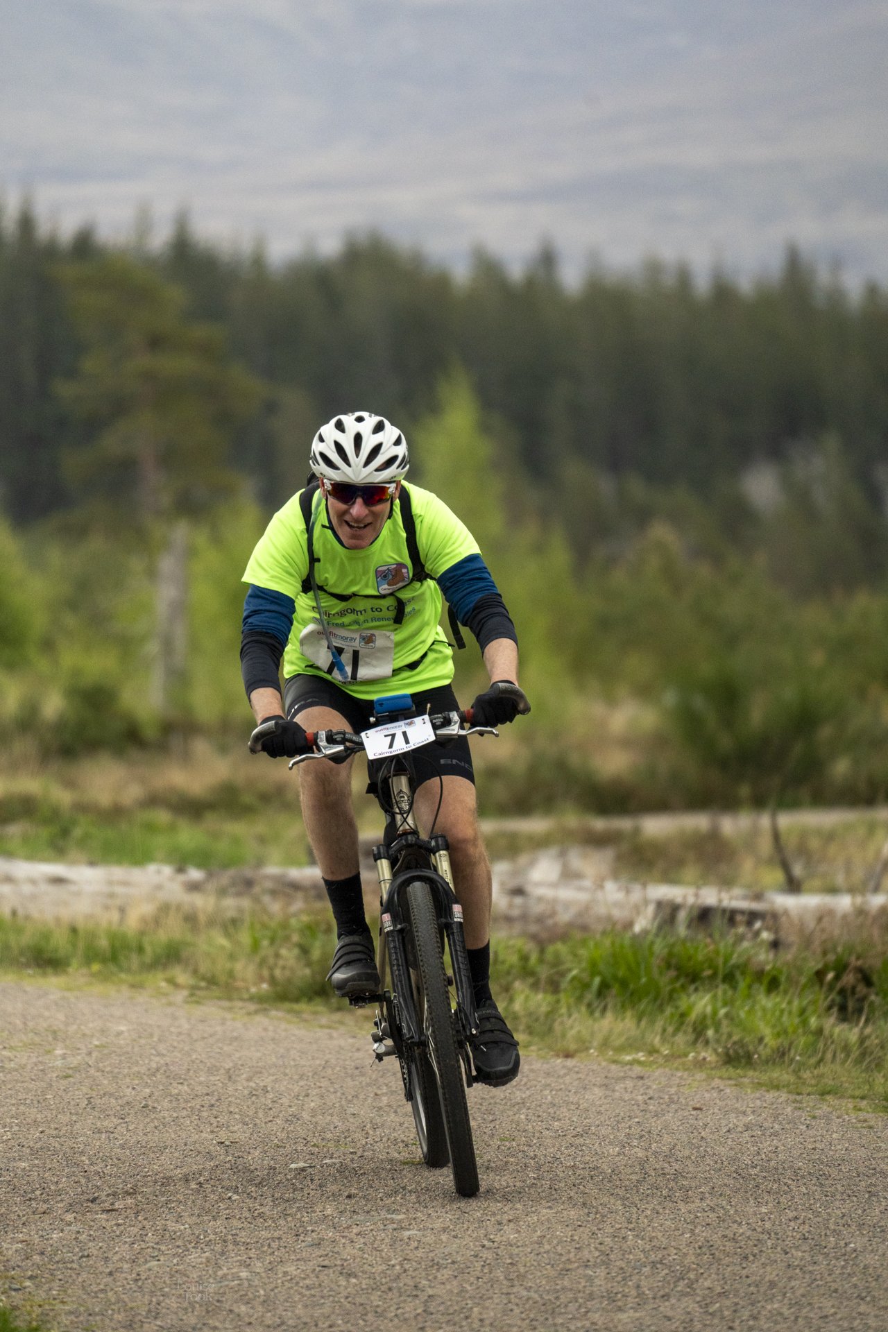 Engaging event photography showing a man cycling in a long distance race through the Highlands of Scotland