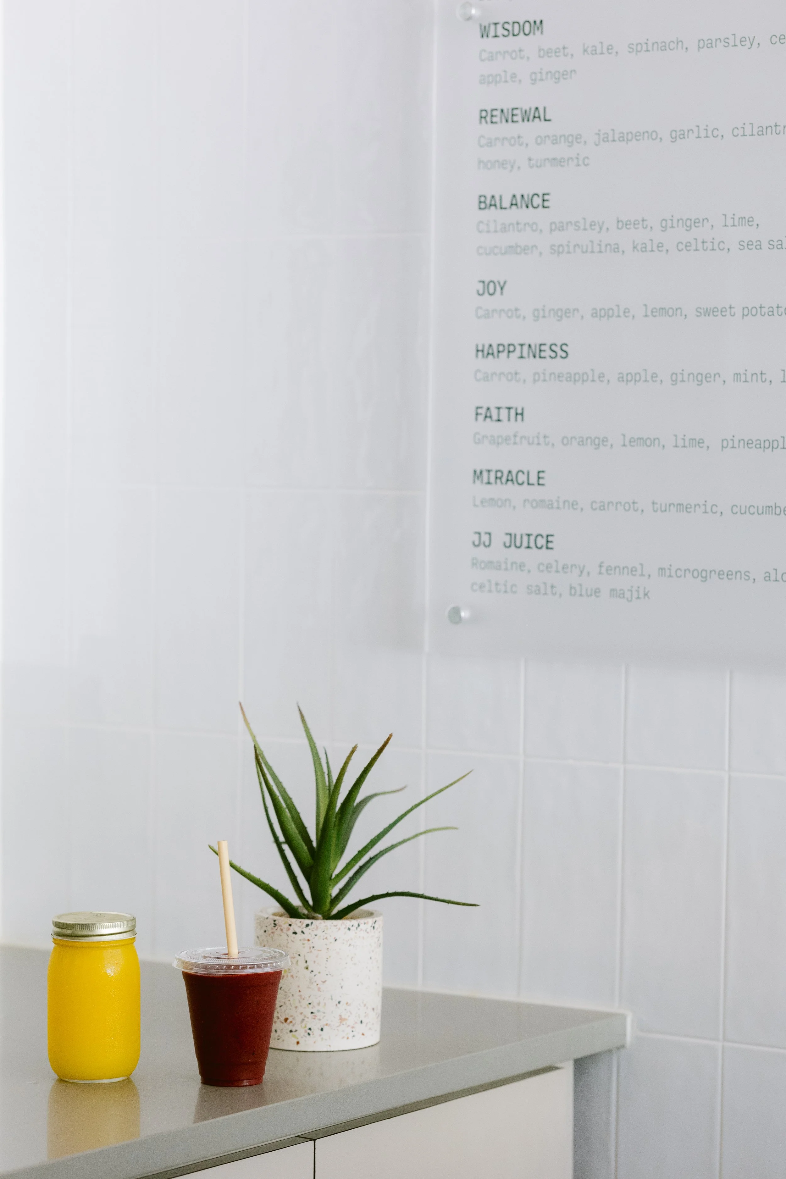 Green Fork & Straw cold-pressed juice menu listing Wisdom, Renewal, Balance, Joy, and Happiness blends