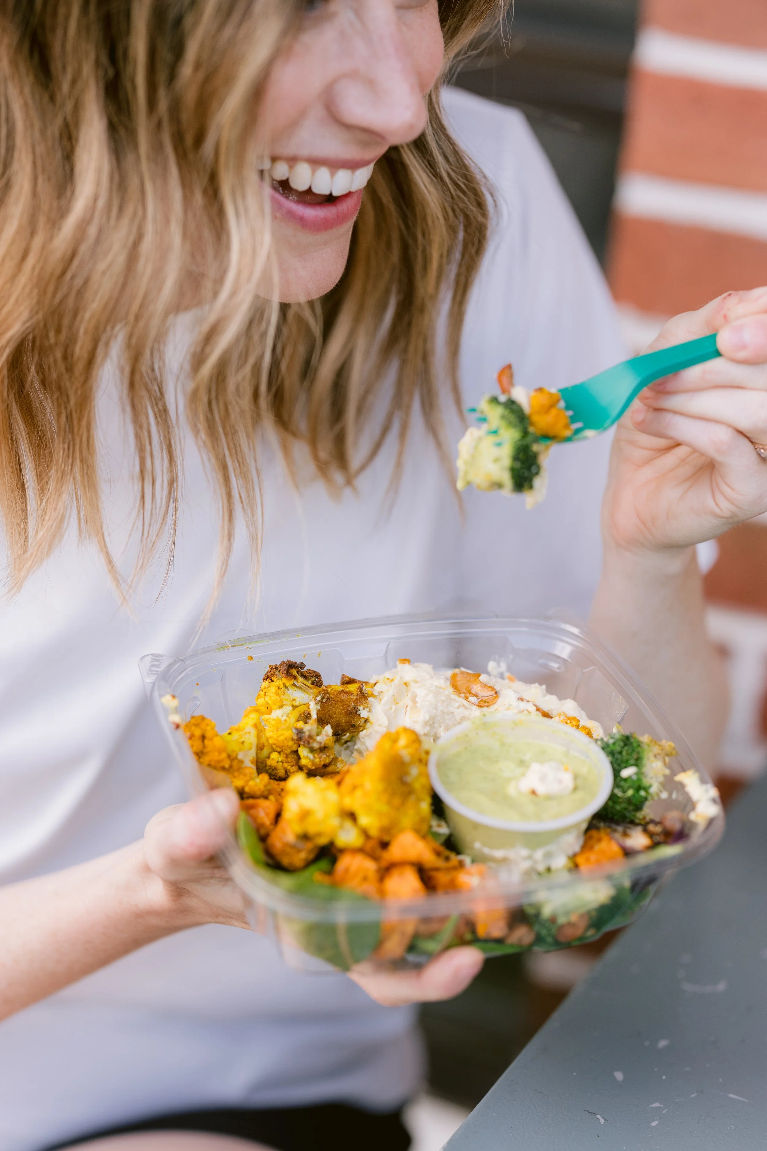 Woman enjoying organic meal prep from Green Fork & Straw catering order