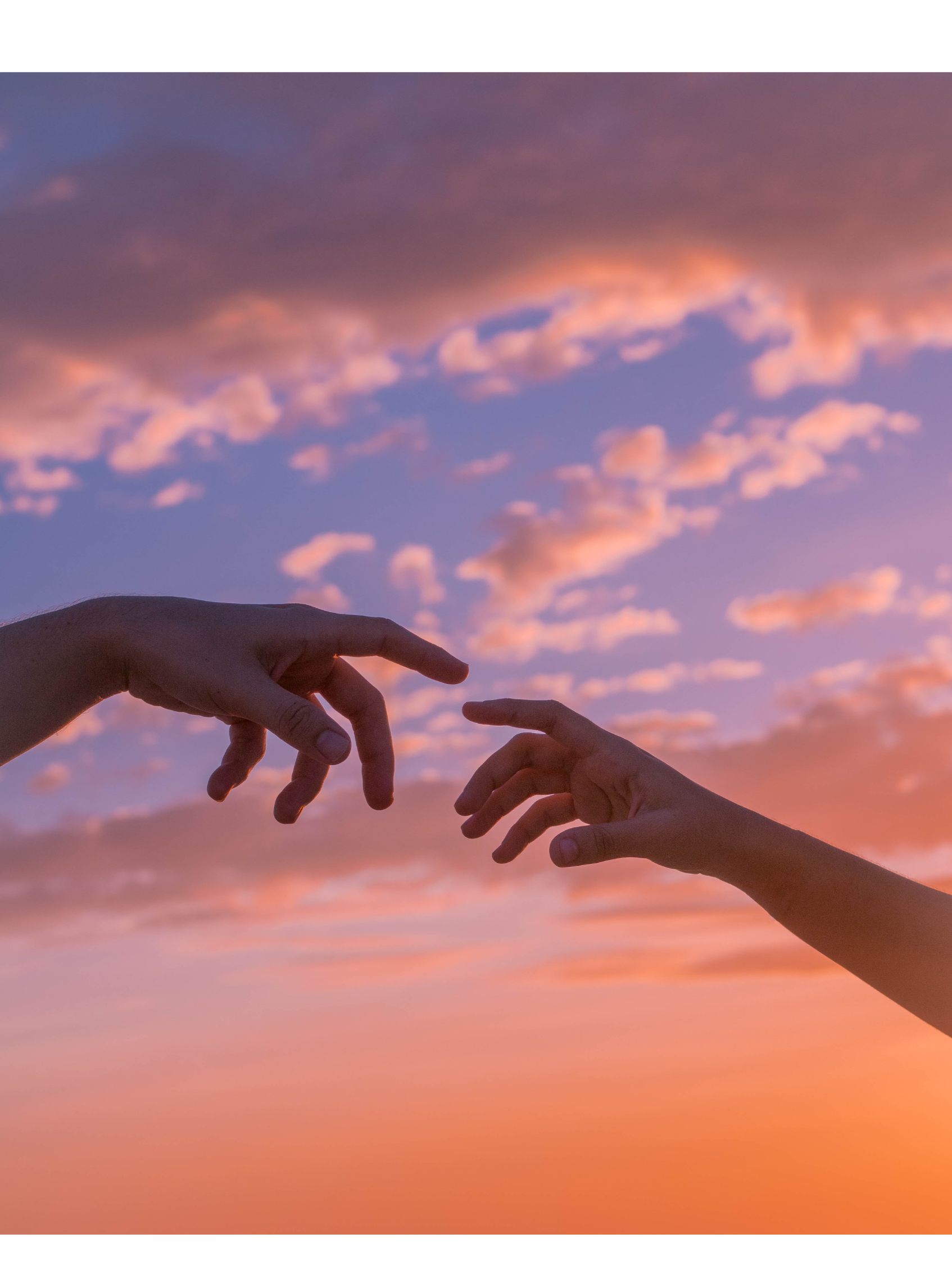 Two hands reaching towards each other against a colorful sunset sky with pink and purple clouds.