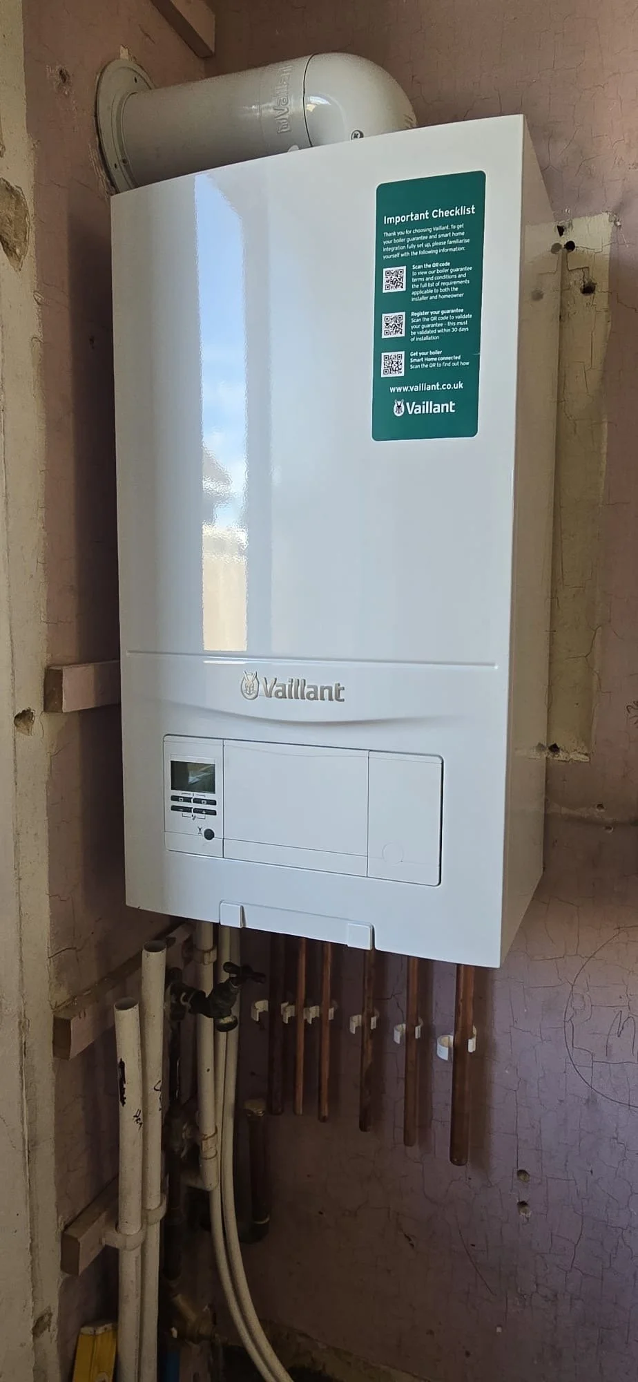 A Vaillant boiler installed on a wall with pipes underneath, Installed by Chris Murphy Plumbing and Heating 2026