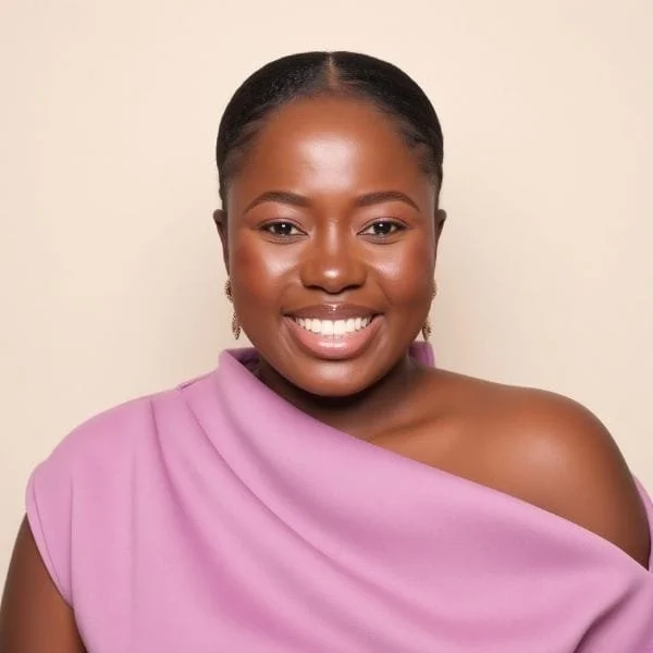 A smiling woman with dark skin, wearing a purple one-shoulder top and earrings.