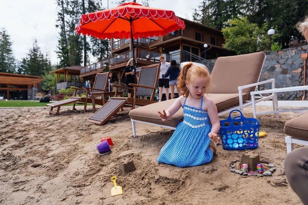 A child building a sandcastle on the beach at The Retreat on Lake Pend Oreille