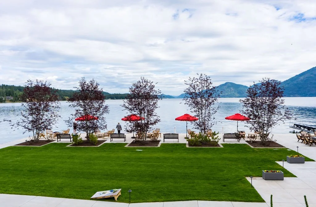The lakefront lawn and red umbrellas at The Retreat on Lake Pend Oreille in Sagle, Idaho