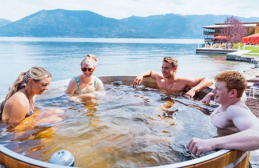 Four guests in the lakefront hot tub at The Retreat on Lake Pend Oreille in Sagle, Idaho