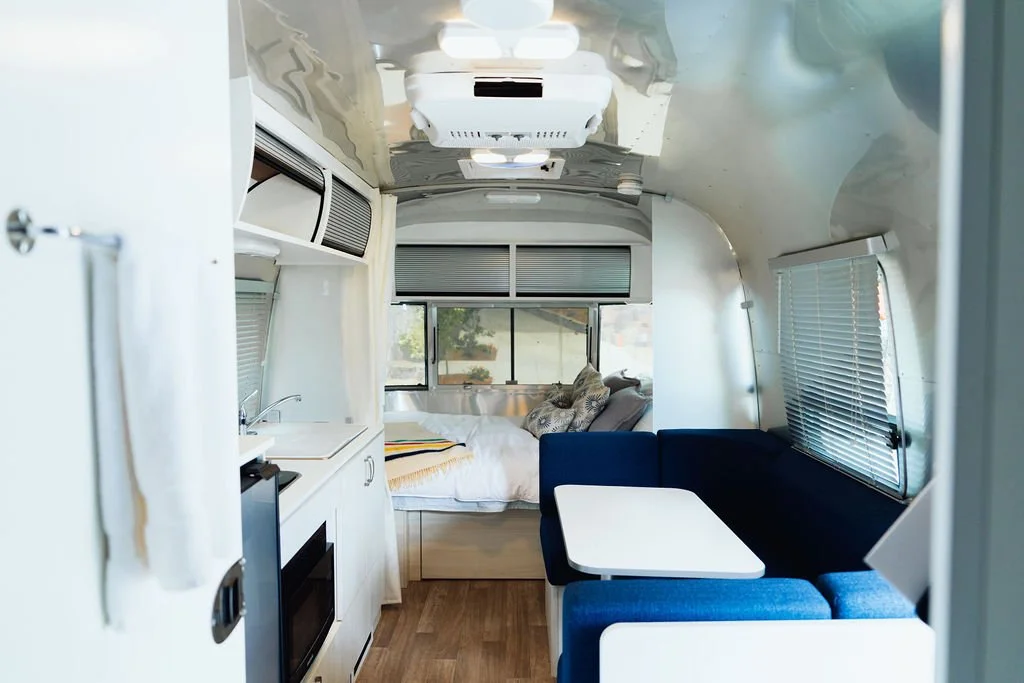 Interior of the Airstream with a bed and kitchenette at The Retreat on Lake Pend Oreille