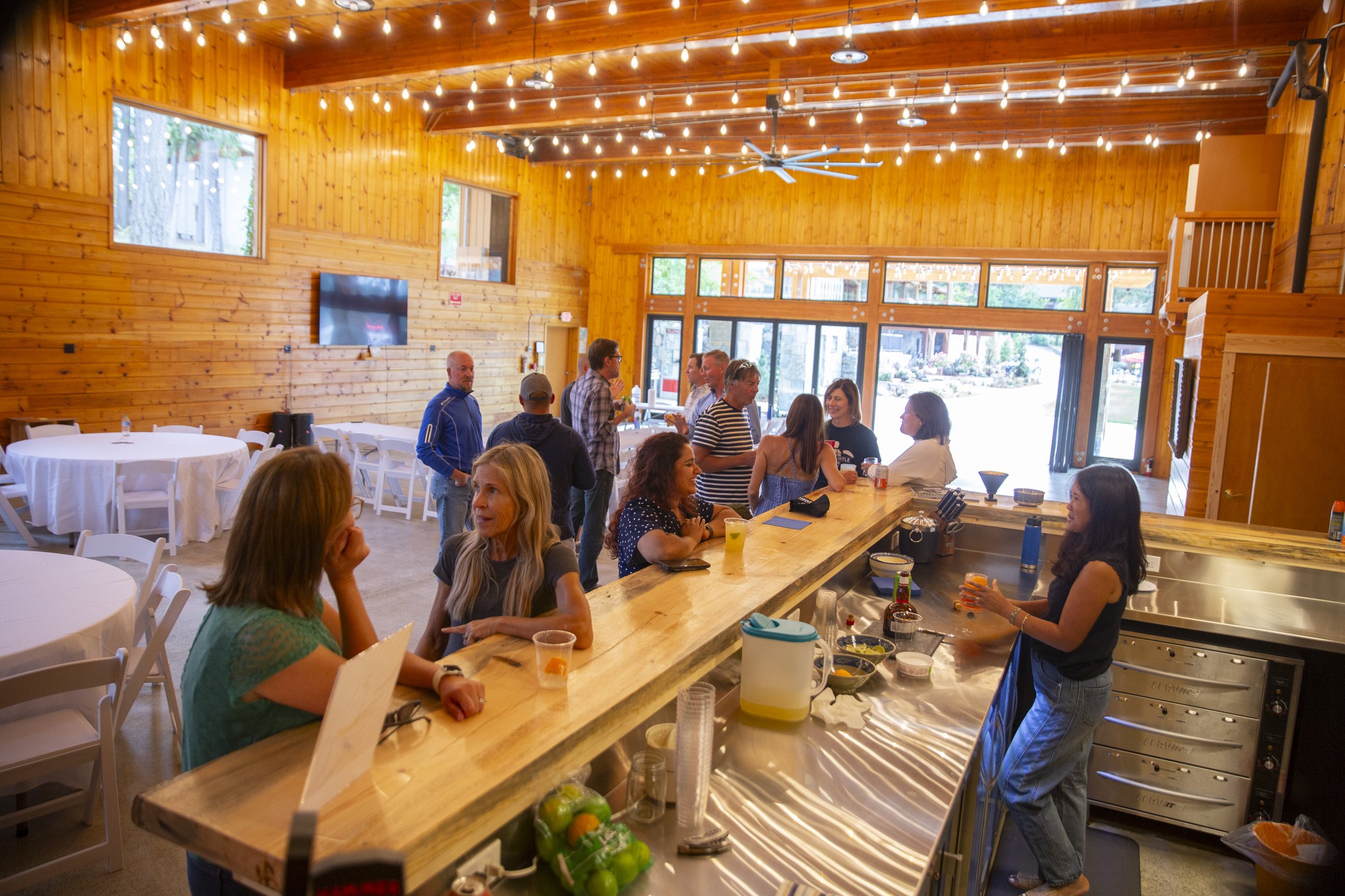 Guests in the wood-paneled event space under string lights at The Retreat on Lake Pend Oreille