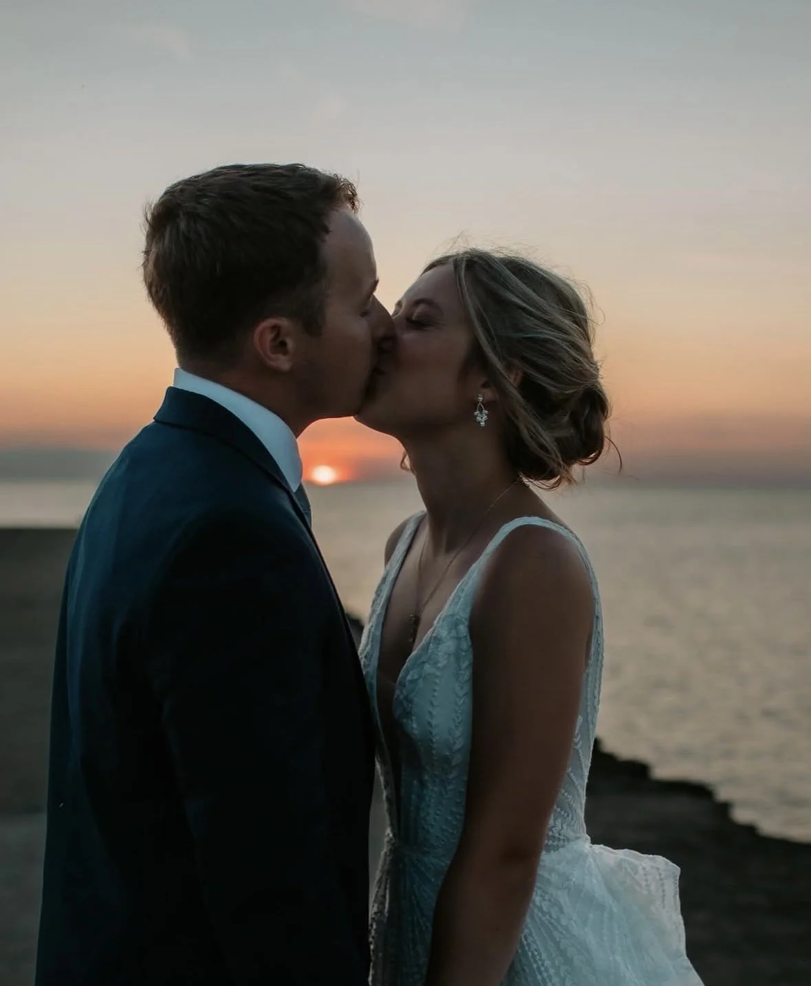 Wedding couple sharing a kiss at sunset beside Lake Pend Oreille in Sagle, Idaho