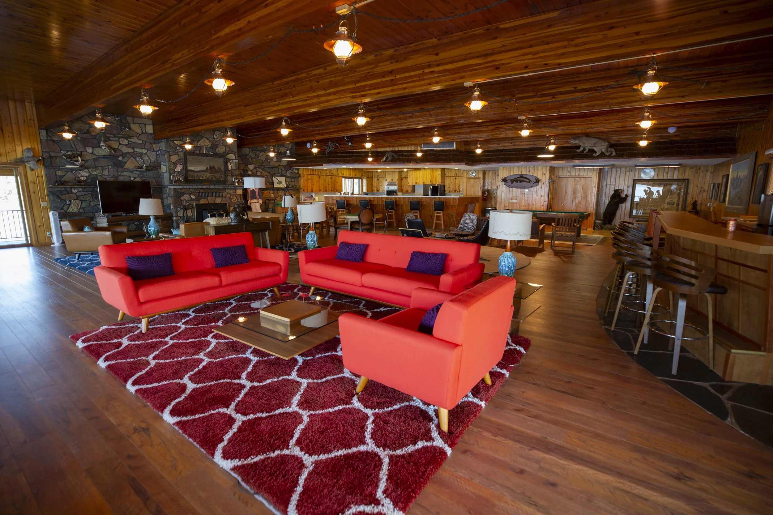 Lodge lounge with red sofas and a stone fireplace at The Retreat on Lake Pend Oreille