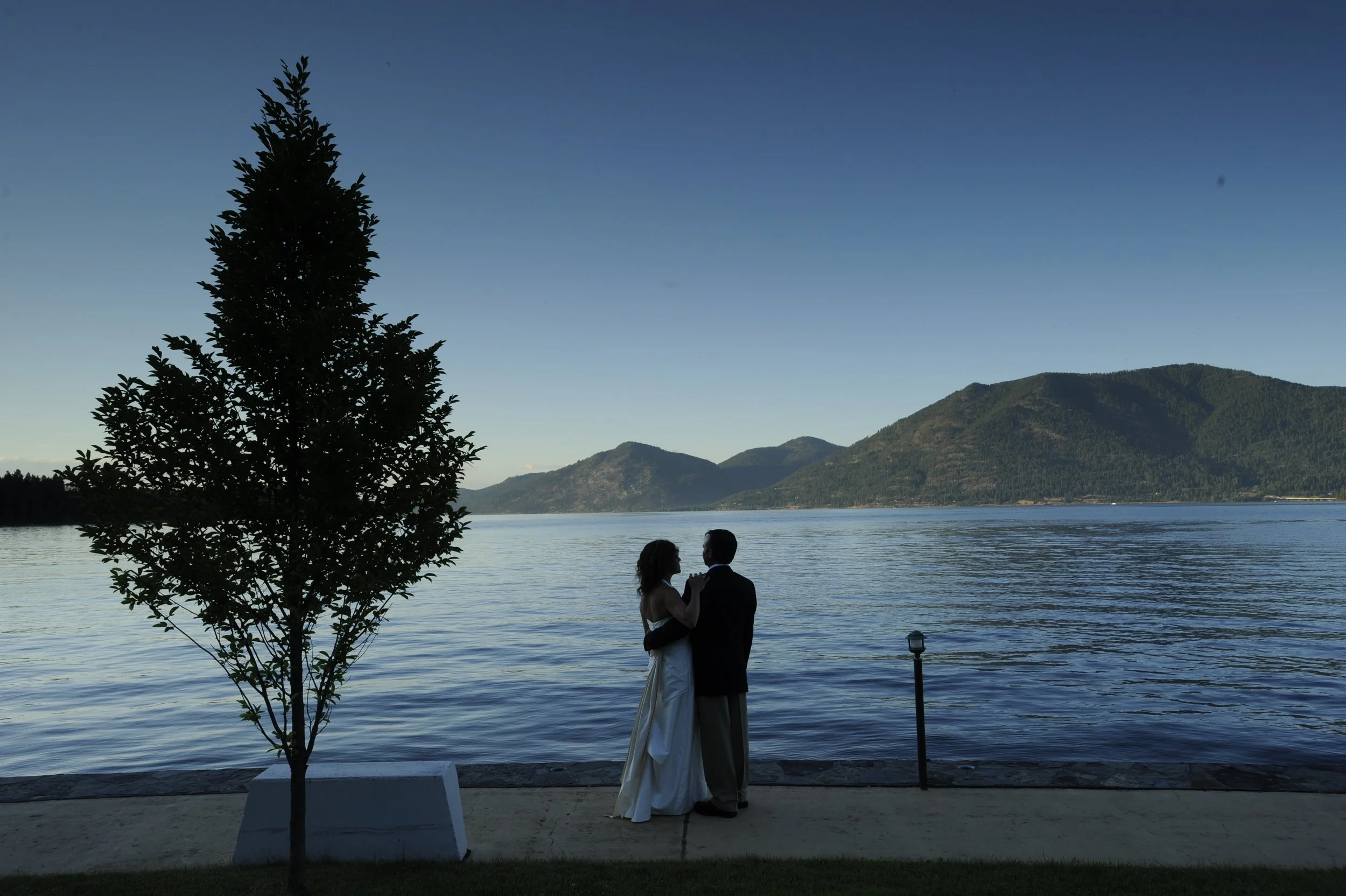 Bride and groom at dusk on the shore of Lake Pend Oreille in Sagle, Idaho