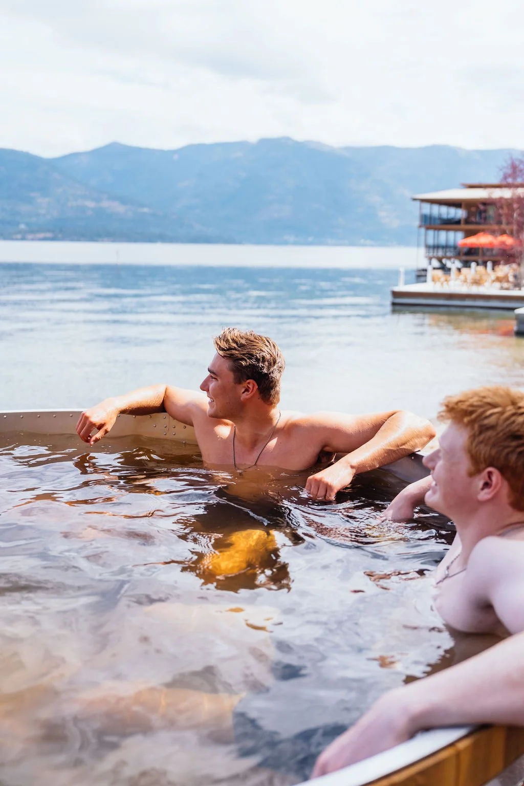 Two guests in the hot tub on the lakeside deck at The Retreat on Lake Pend Oreille