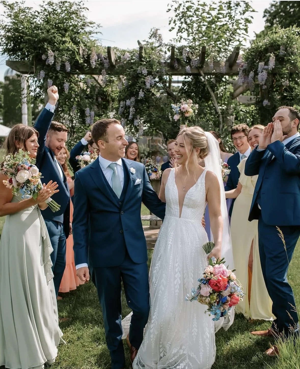 Newlyweds celebrating with their wedding party on the lawn at The Retreat on Lake Pend Oreille