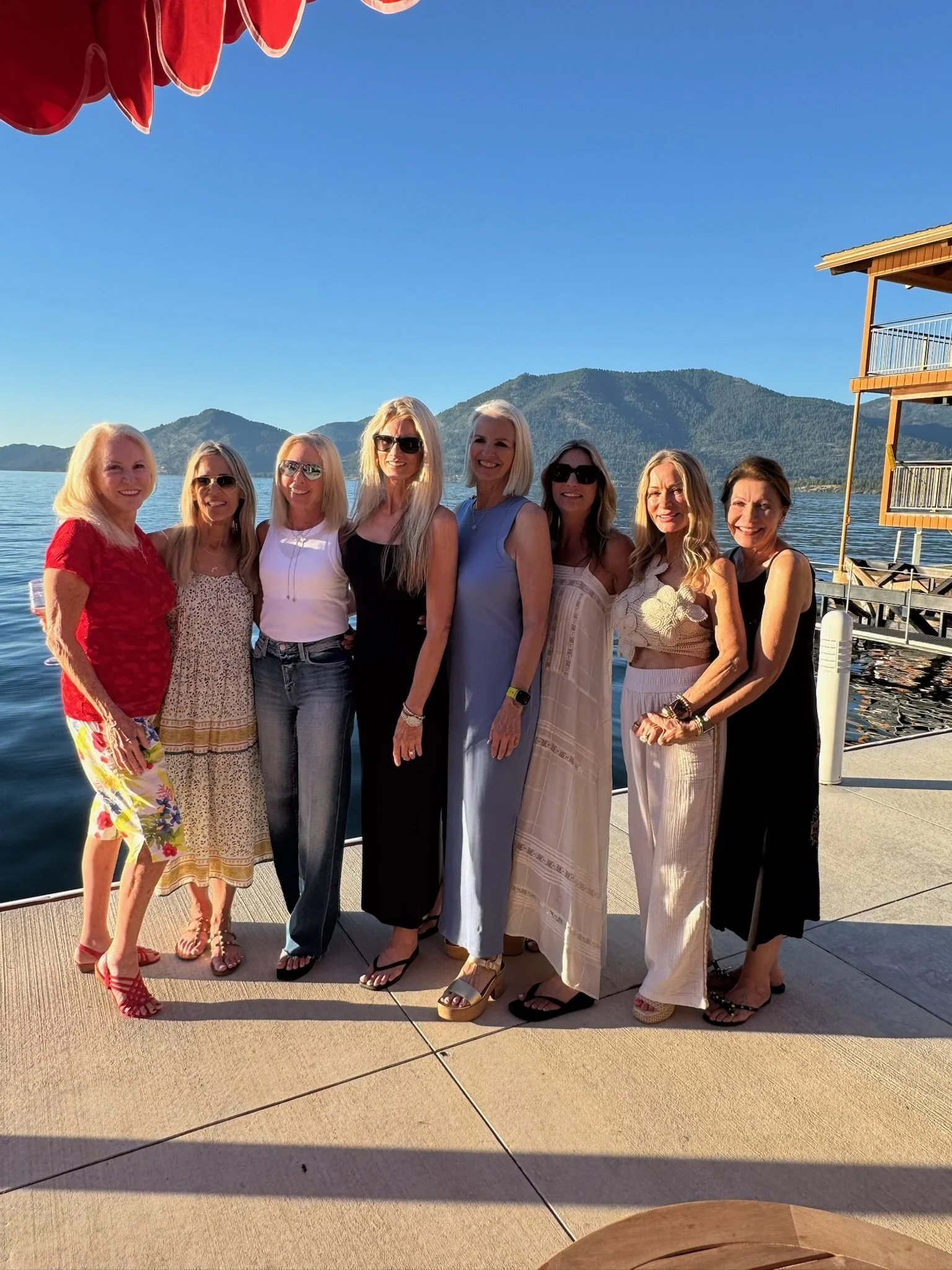 Eight friends gathered at the water's edge at sunset at The Retreat on Lake Pend Oreille in Sagle, Idaho