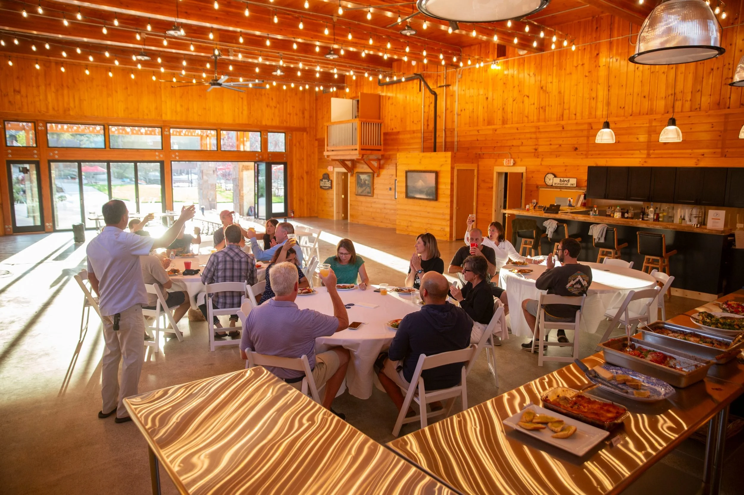 Guests dining at round tables under string lights at The Retreat on Lake Pend Oreille