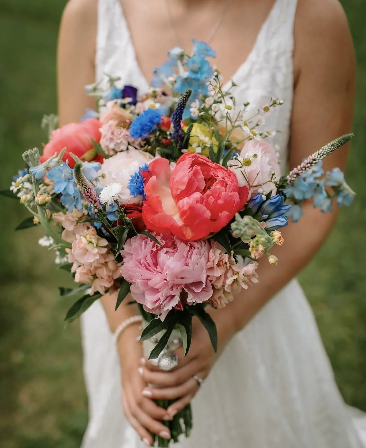 Bride holding a pink and blue summer bouquet at a wedding on Lake Pend Oreille in Sagle, Idaho