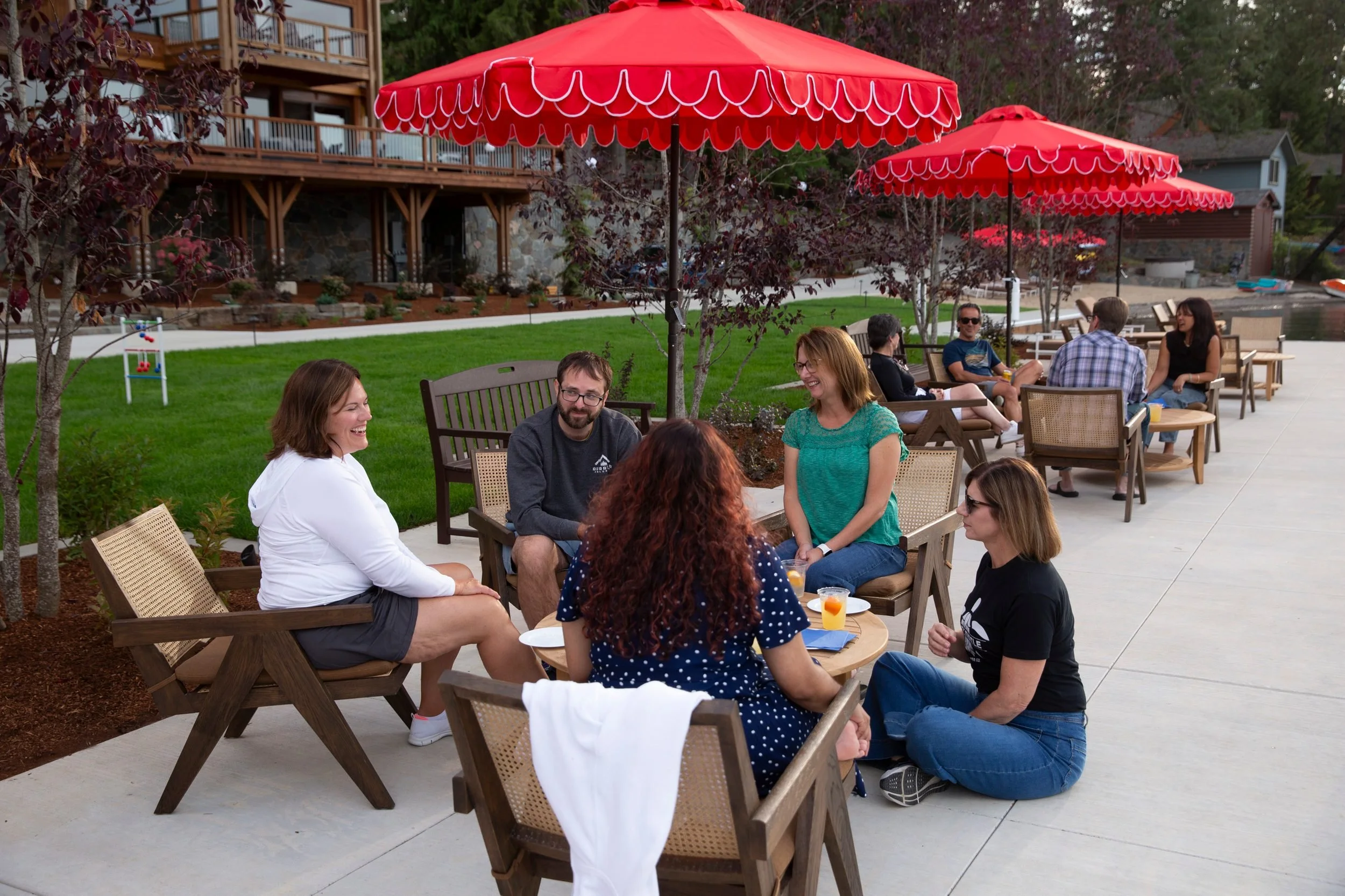 Guests enjoying drinks at umbrella tables at The Retreat on Lake Pend Oreille in Sagle, Idaho