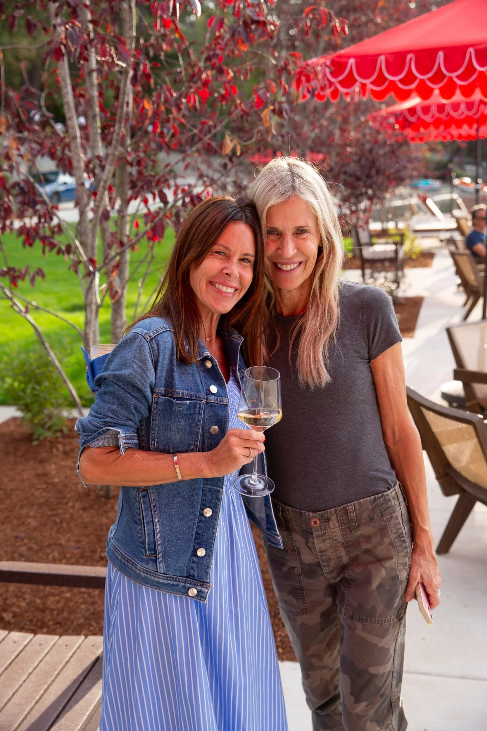 Two guests with wine under the red umbrellas at The Retreat on Lake Pend Oreille in Sagle, Idaho