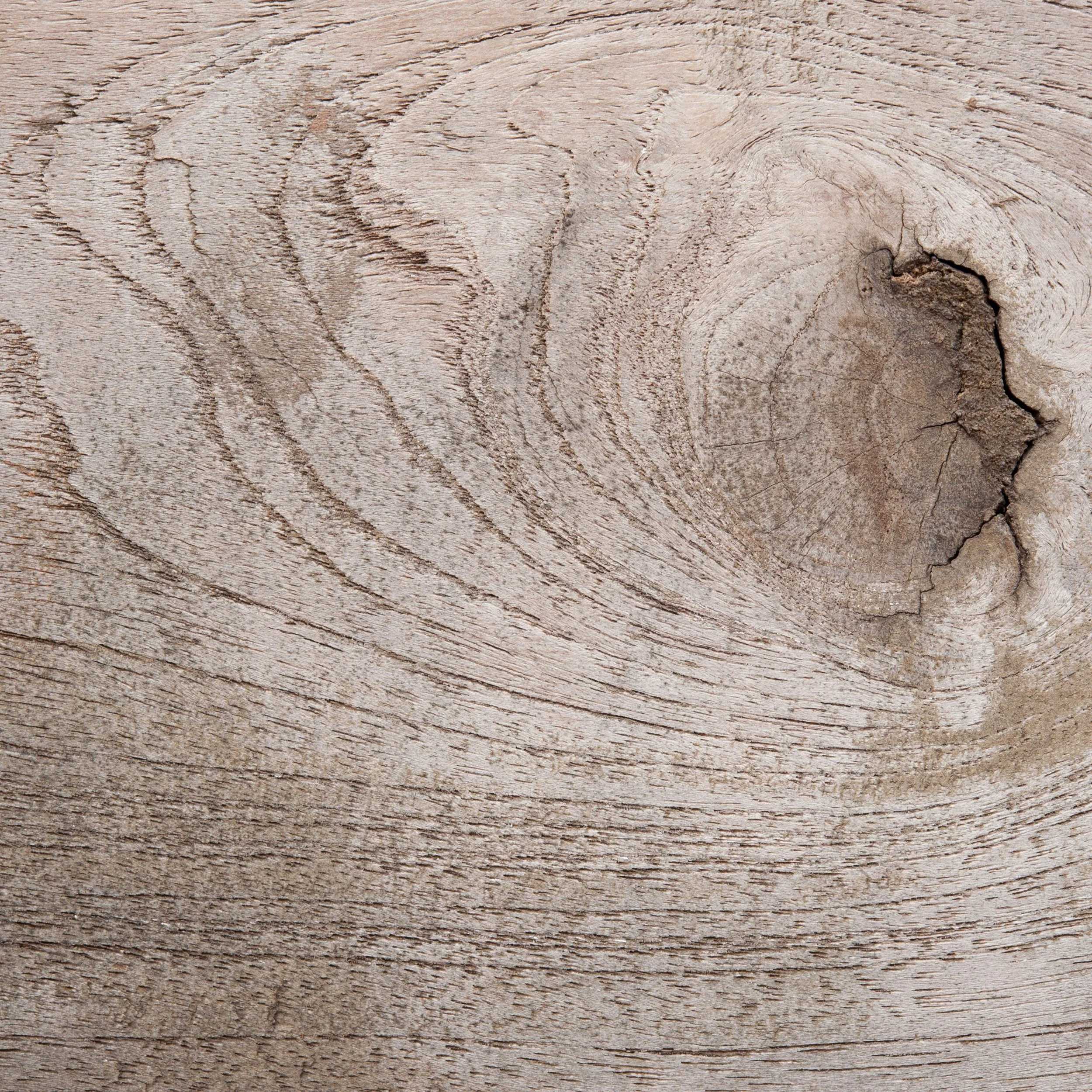 Close-up of weathered, cracked wooden surface with visible grain patterns.