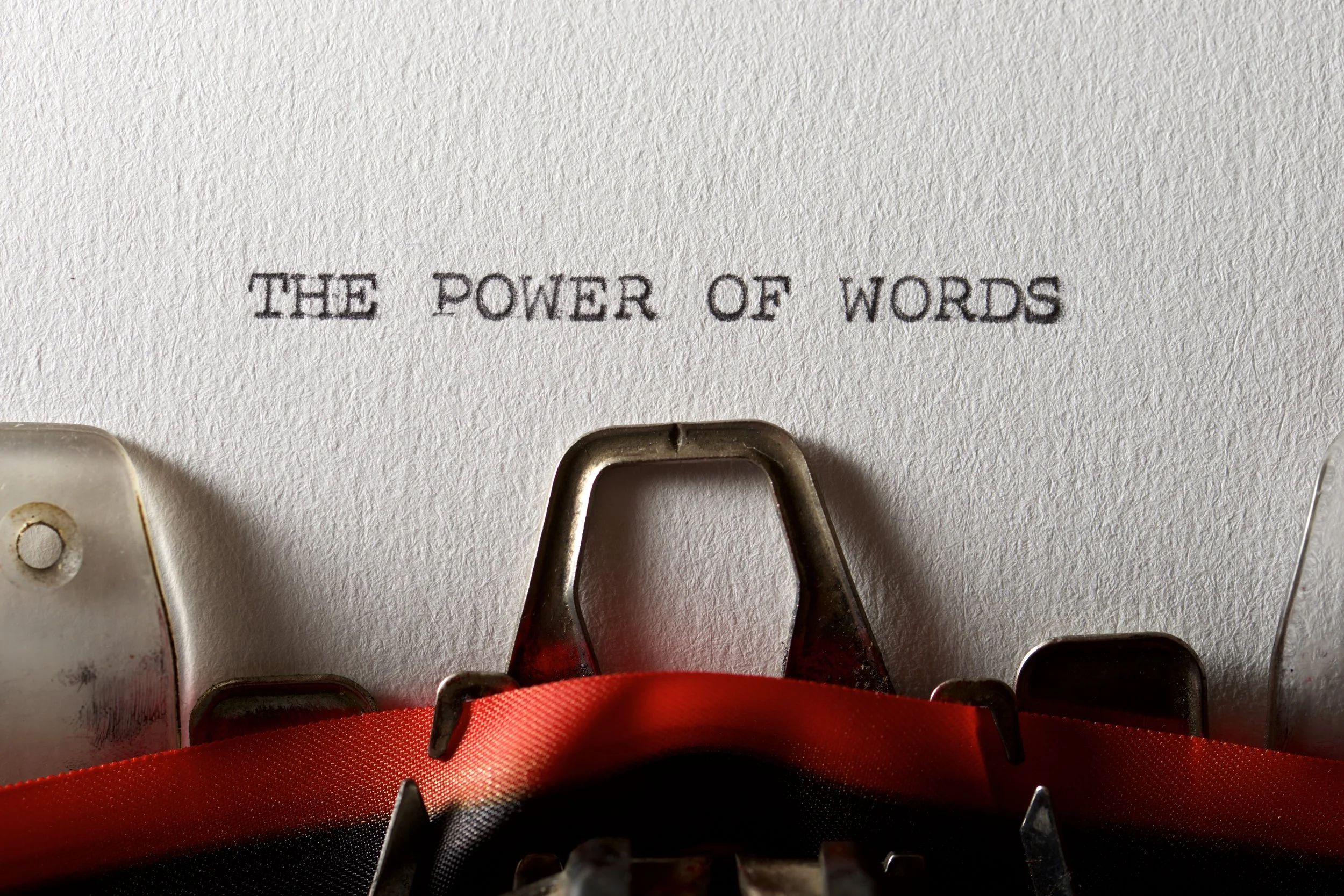Close-up of a typewriter with the phrase 'THE POWER OF WORDS' typed on the paper.