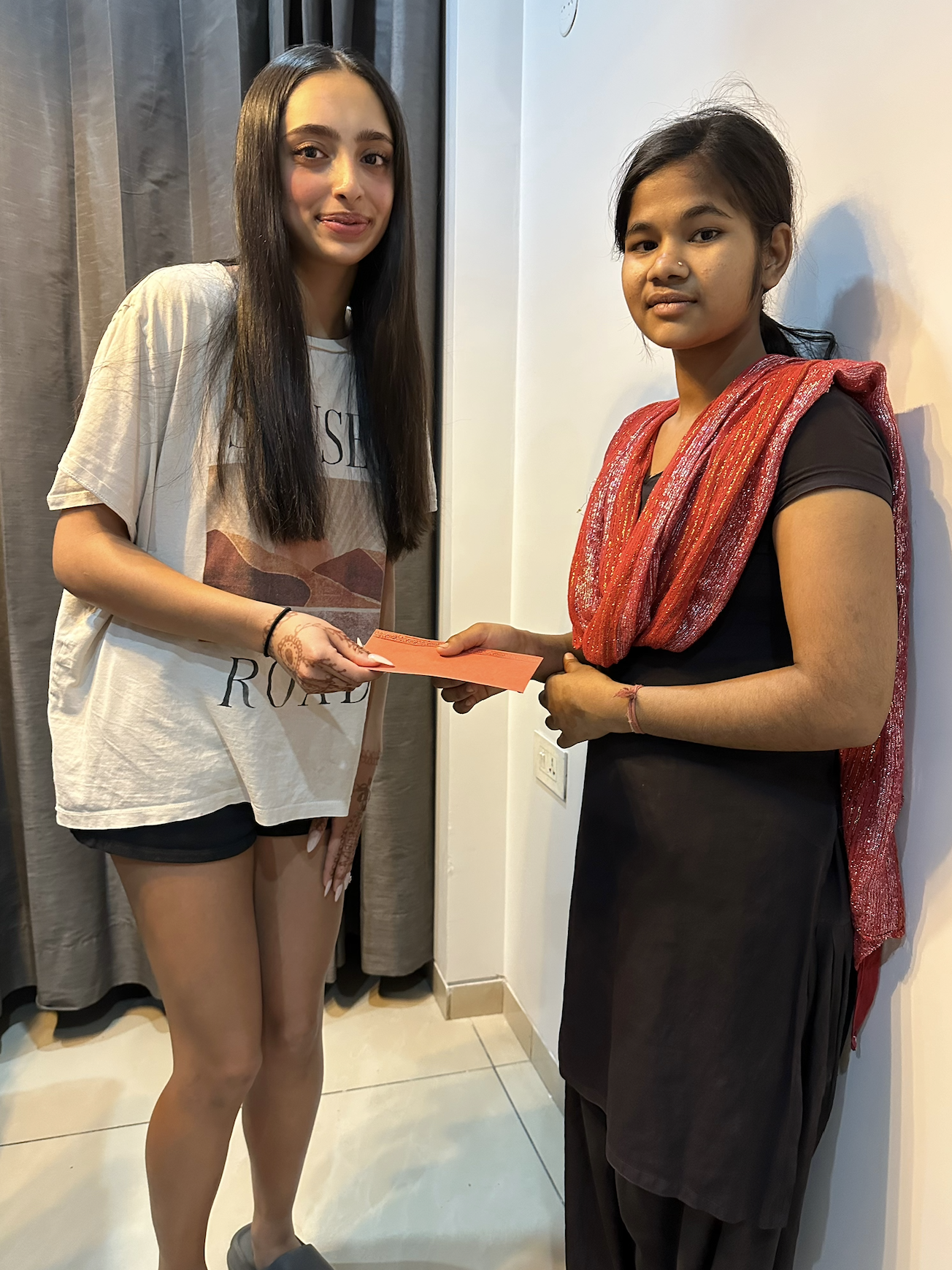 Indian girl giving money to young asian girl