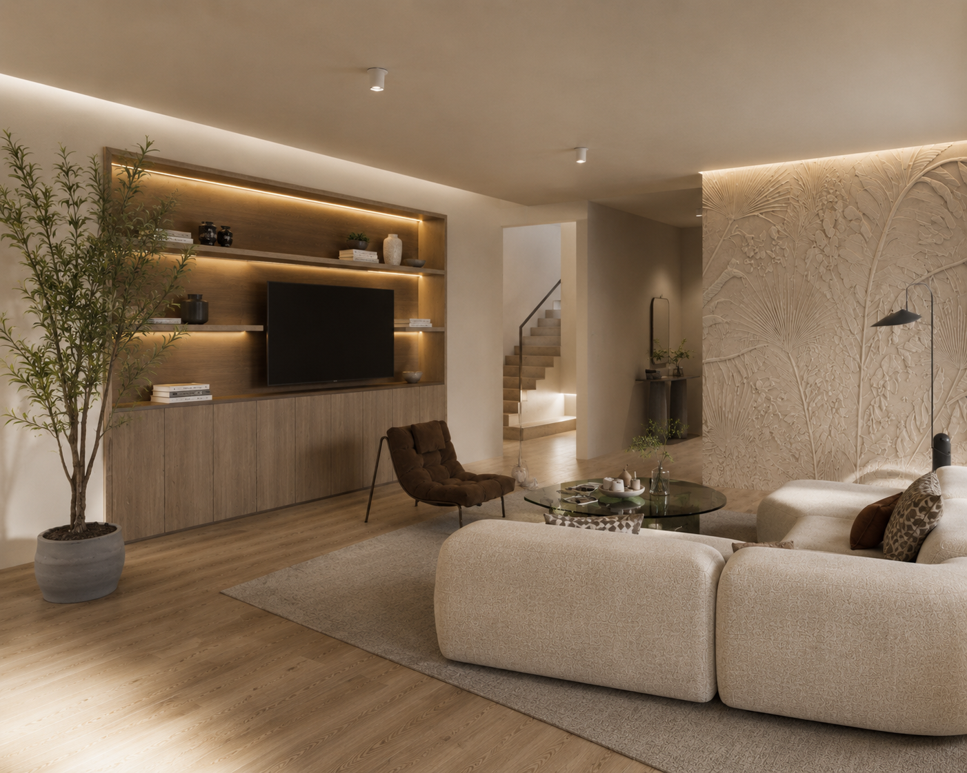 Living room with beige sectional sofa, glass coffee table, brown armchair, potted plant, textured wall, built-in wooden shelving with TV, and wooden flooring.