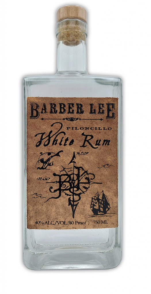 A clear glass bottle of Barber Lee Piloncillo White Rum with a wooden cap and a vintage-style label featuring a ship, nautical elements, and text.