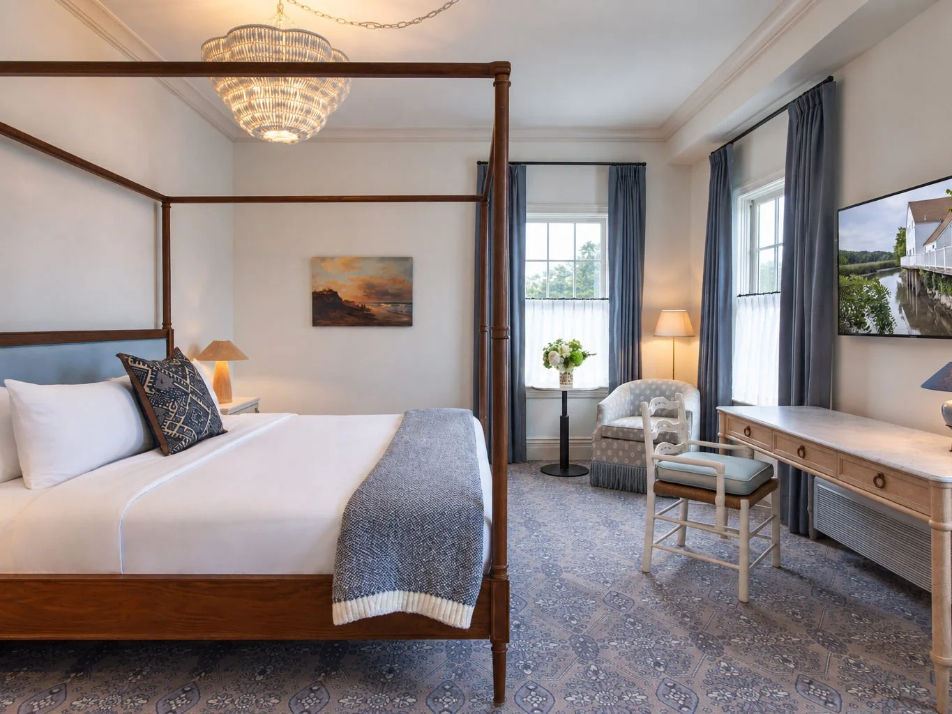 A sitting room laid out for two, chairs drawn up to the windows