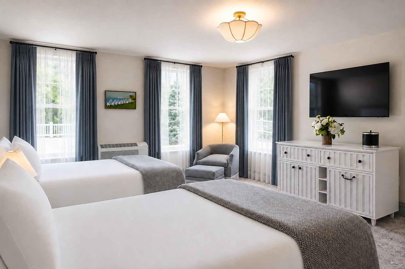 A second-floor guest room, bed alongside a sitting area and a writing desk