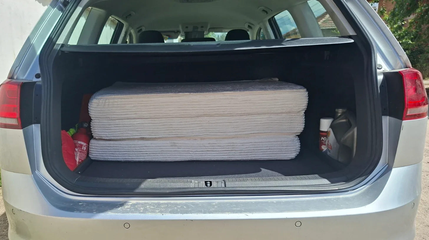 Folded mattress stored under the parcel shelf in a VW Golf Estate, creating a repeatable day-mode travel setup.