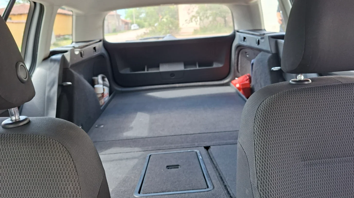Empty cargo area of a 2014 VW Golf Estate with rear seats folded flat before conversion into a two-person sleeping setup.