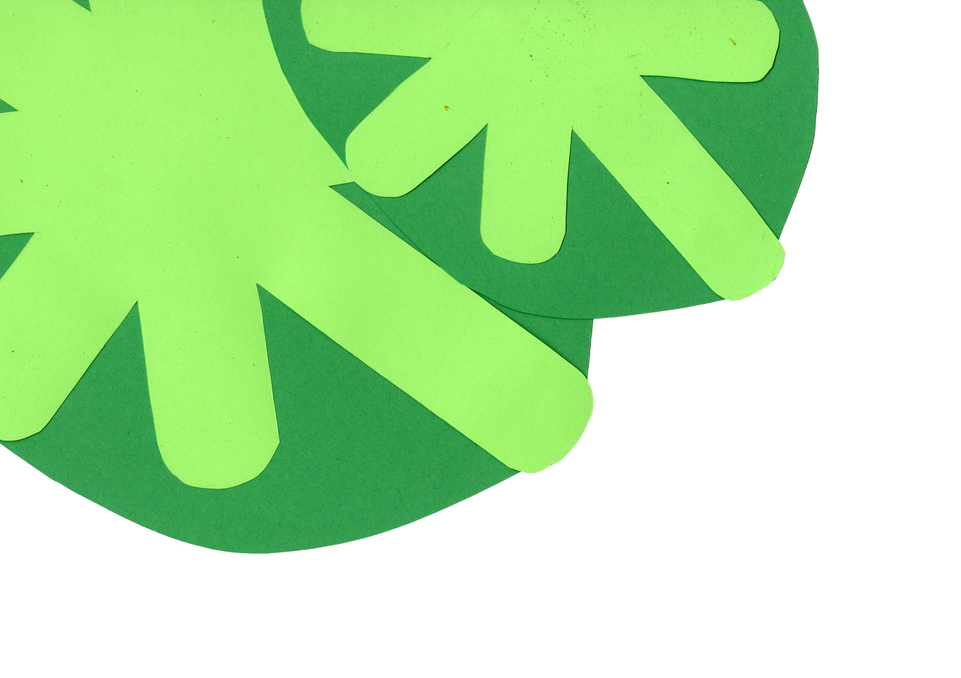 Close-up of bright green paper shamrock decorations on dark green paper background.