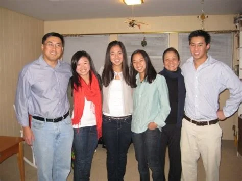 Six people standing close together indoors, smiling at the camera.