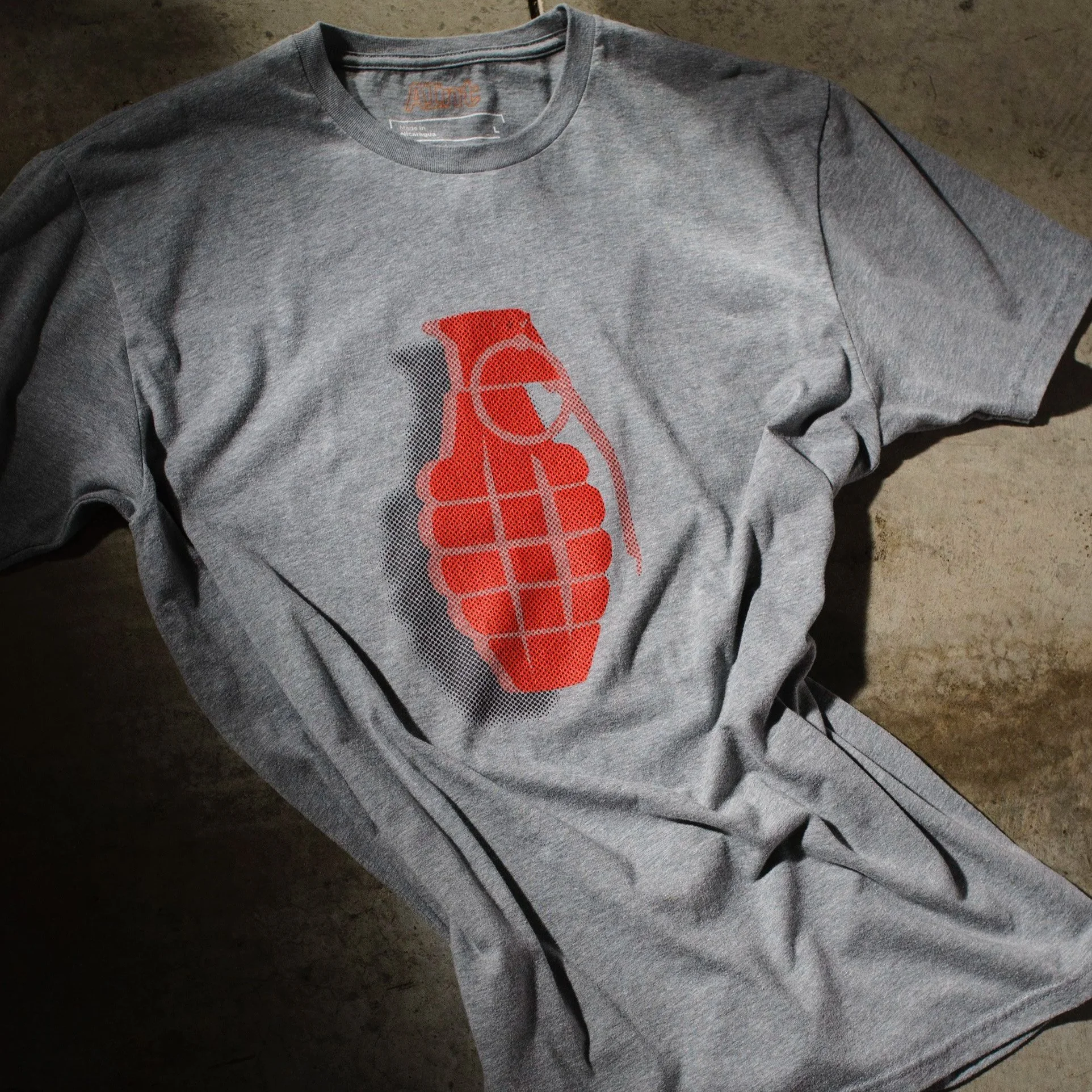 AInt-dark-heather-gray-grenade-t-shirt-red-halftone-black-drop-shadow-studio-concrete-floor.jpg
