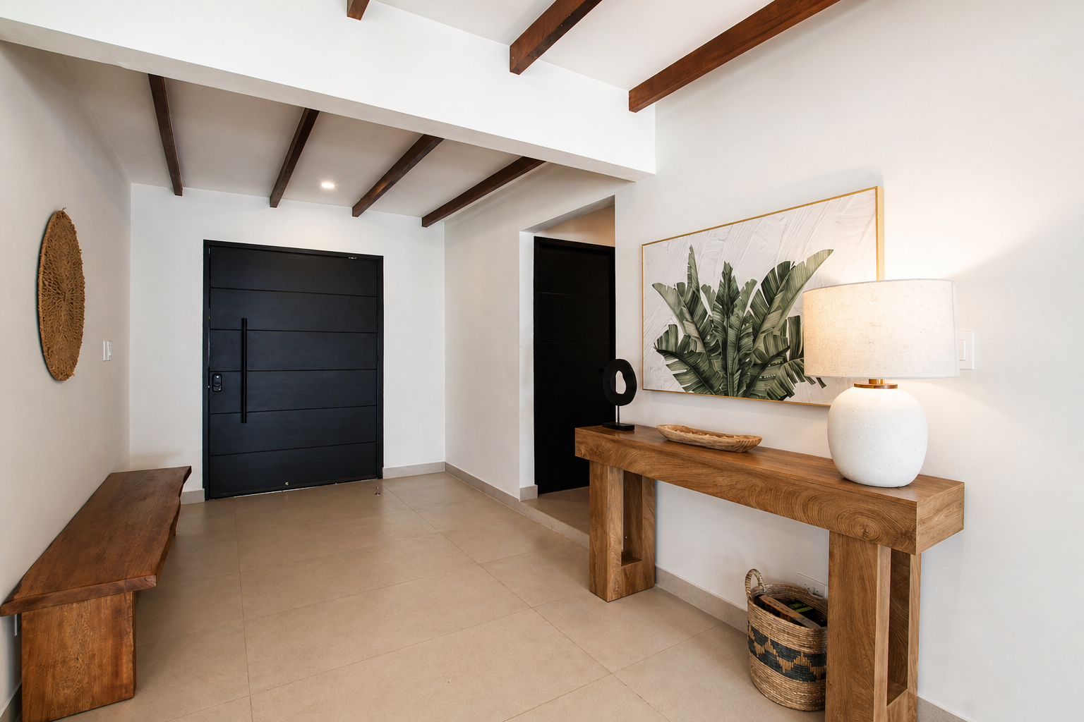 Modern entryway with a black front door, wooden beams on the ceiling, a wooden bench on the left, and a wooden console table on the right with a table lamp, a decorative bowl, a framed botanical print, and a basket underneath.
