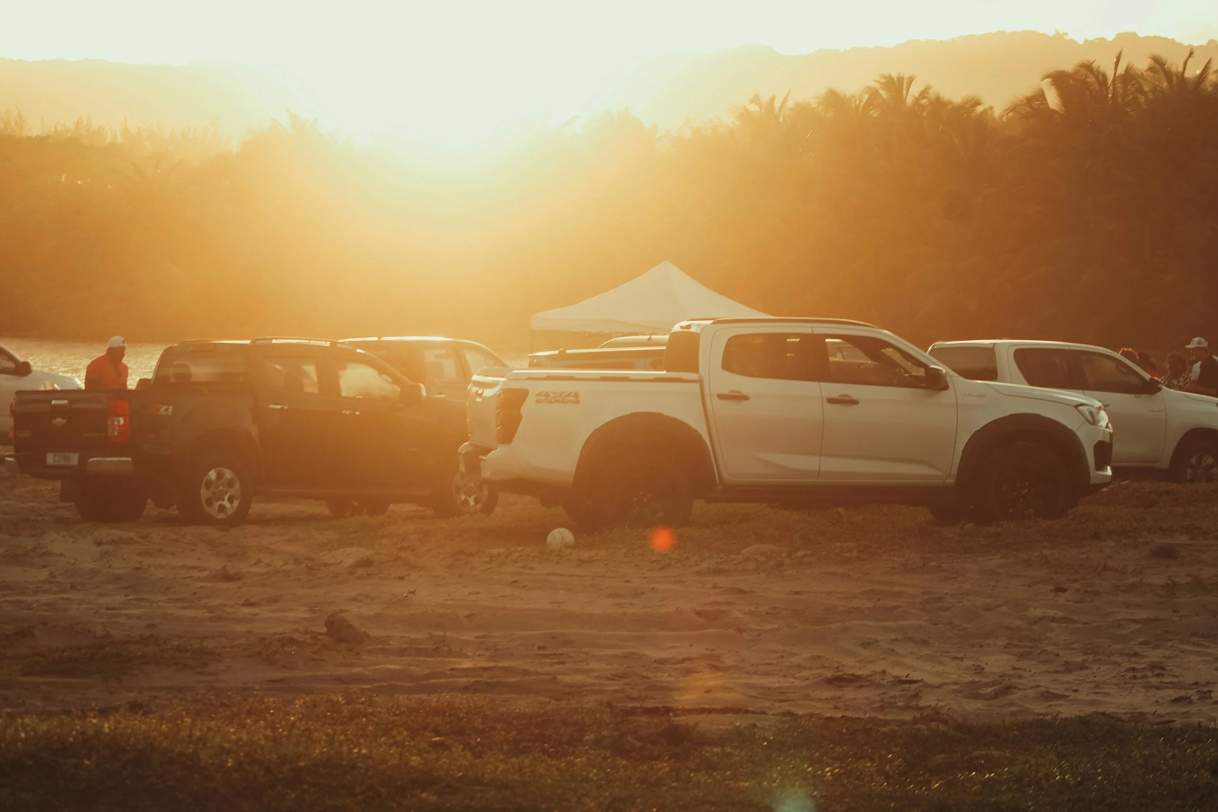 Pickups 4x4 al atardecer en una playa en Guanacaste.