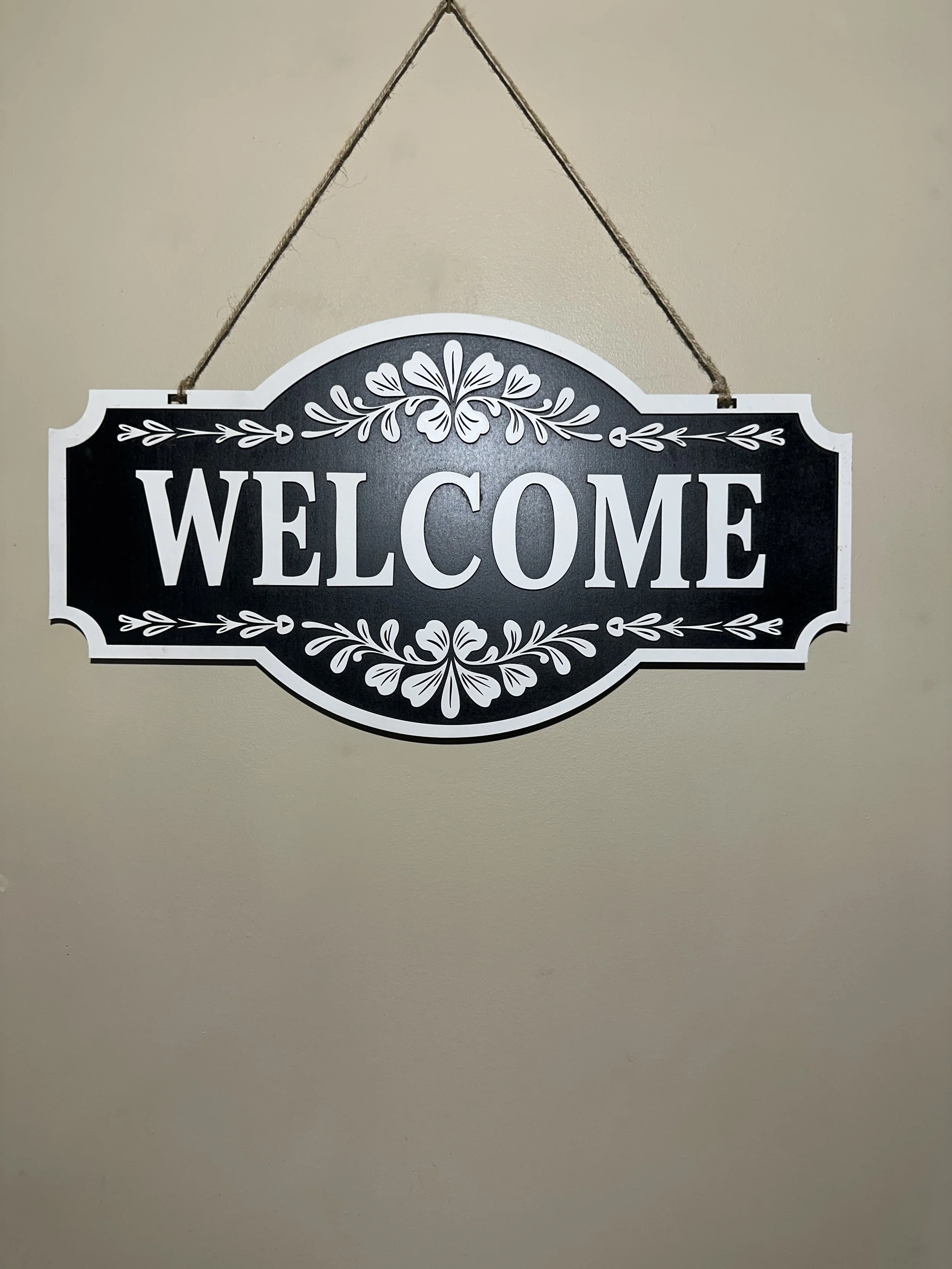 black and white layered wooden welcome sign.
