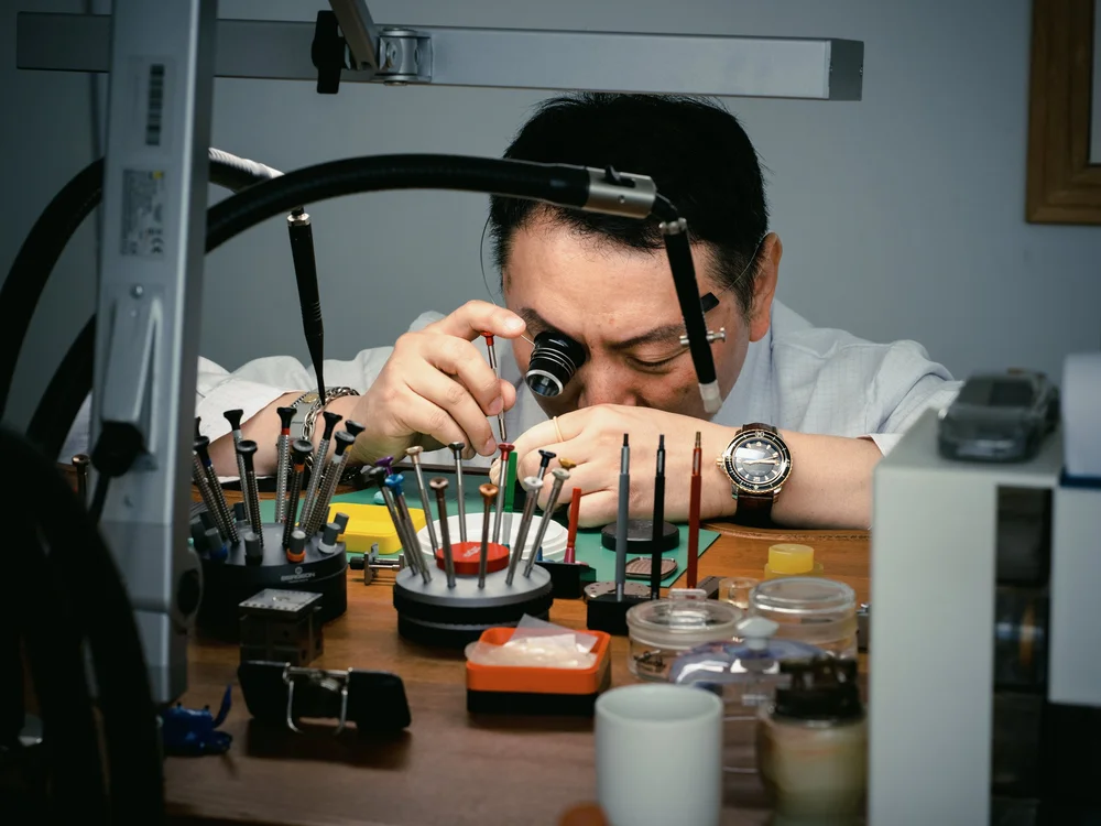 Meridian watchmaker examining a watch at the workbench