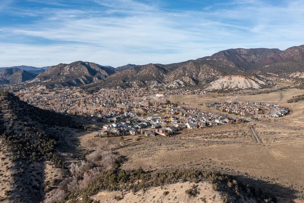 Aerial view of a New Castle nestled in a valley surrounded by mountains in the Western Slope of Colorado.