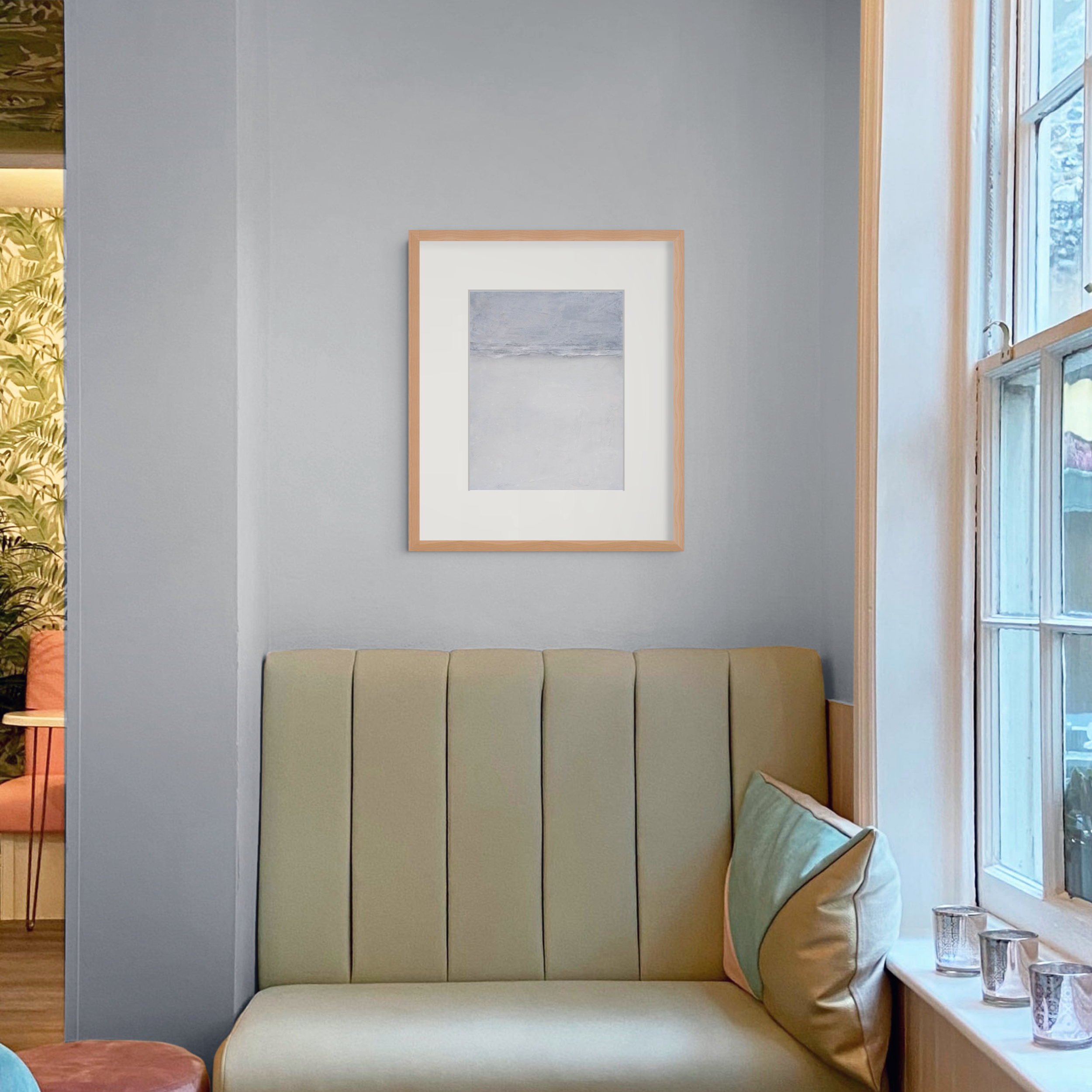 Small abstract landscape painting displayed in a quiet modern interior with gray-blue, warm white, and pale neutral tones.