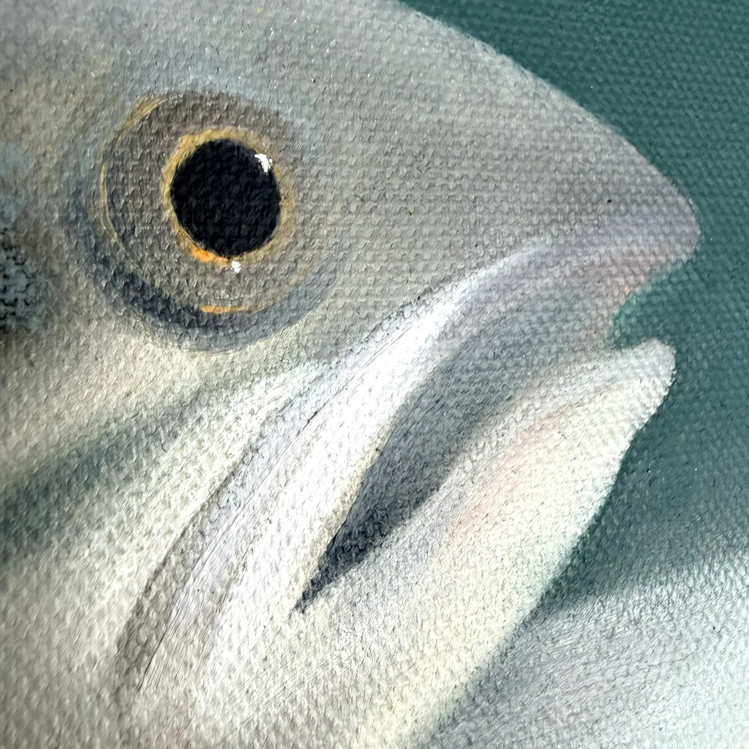 Close-up of a fish still life painted in oil with a bright eye, open mouth, green parsley leaves, yellow lemon wedge, and visible canvas texture.